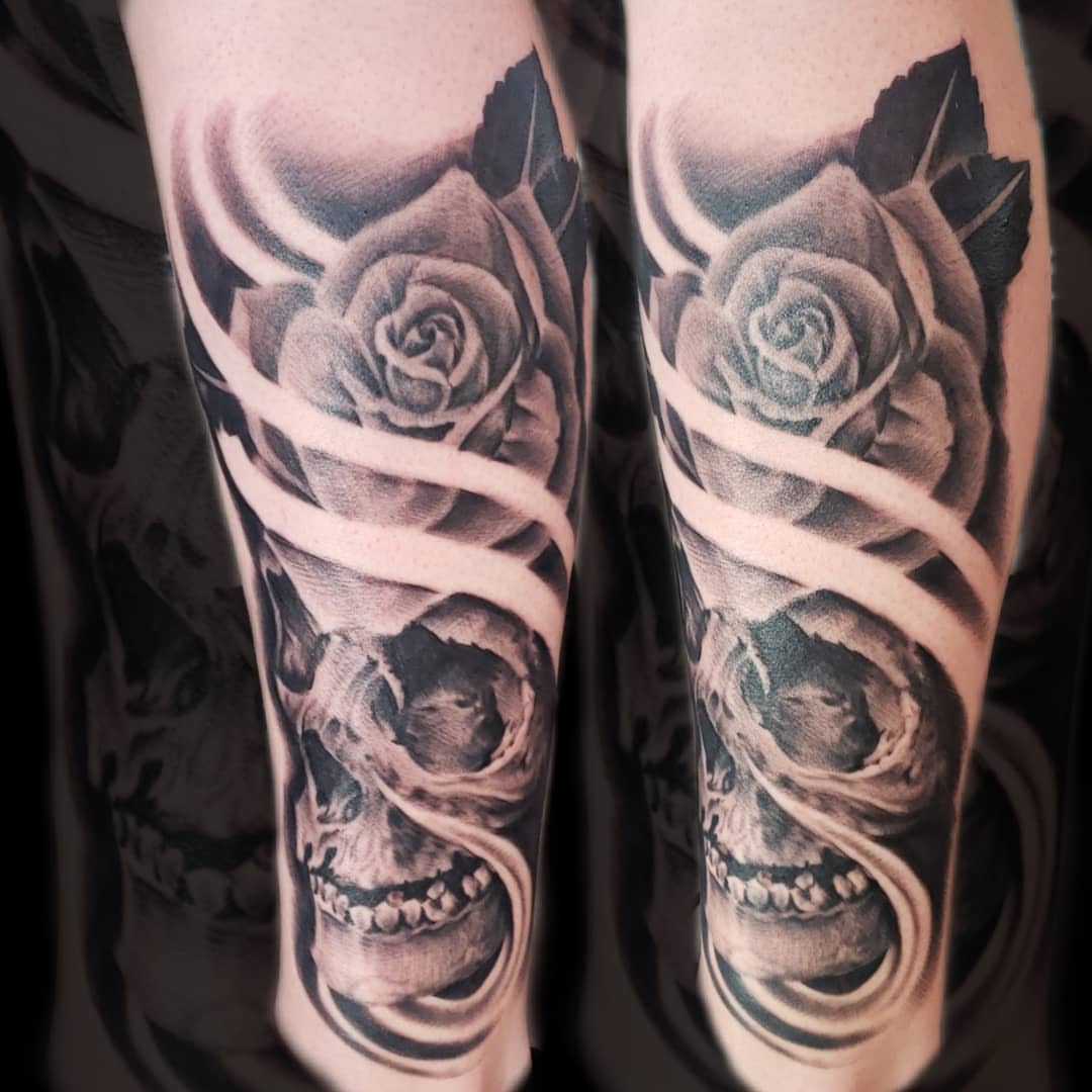 Roses and skulls realism tattoo on the forearm by Mark Melanson