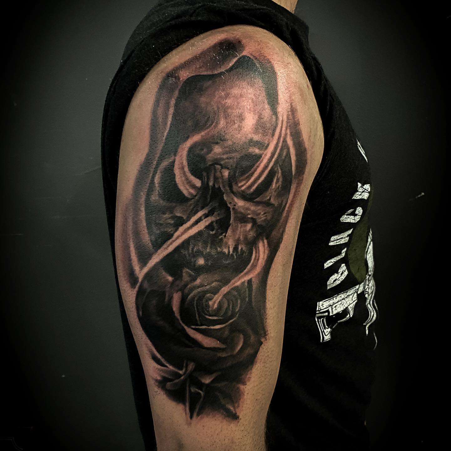 Skull and rose realism tattoo on the upper arm by Jeff Kees