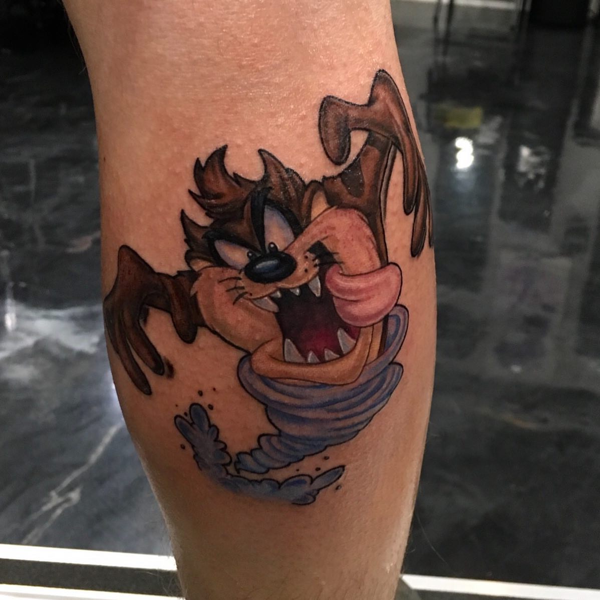 Taz in tornado realism tattoo on the forearm by Ray Marie