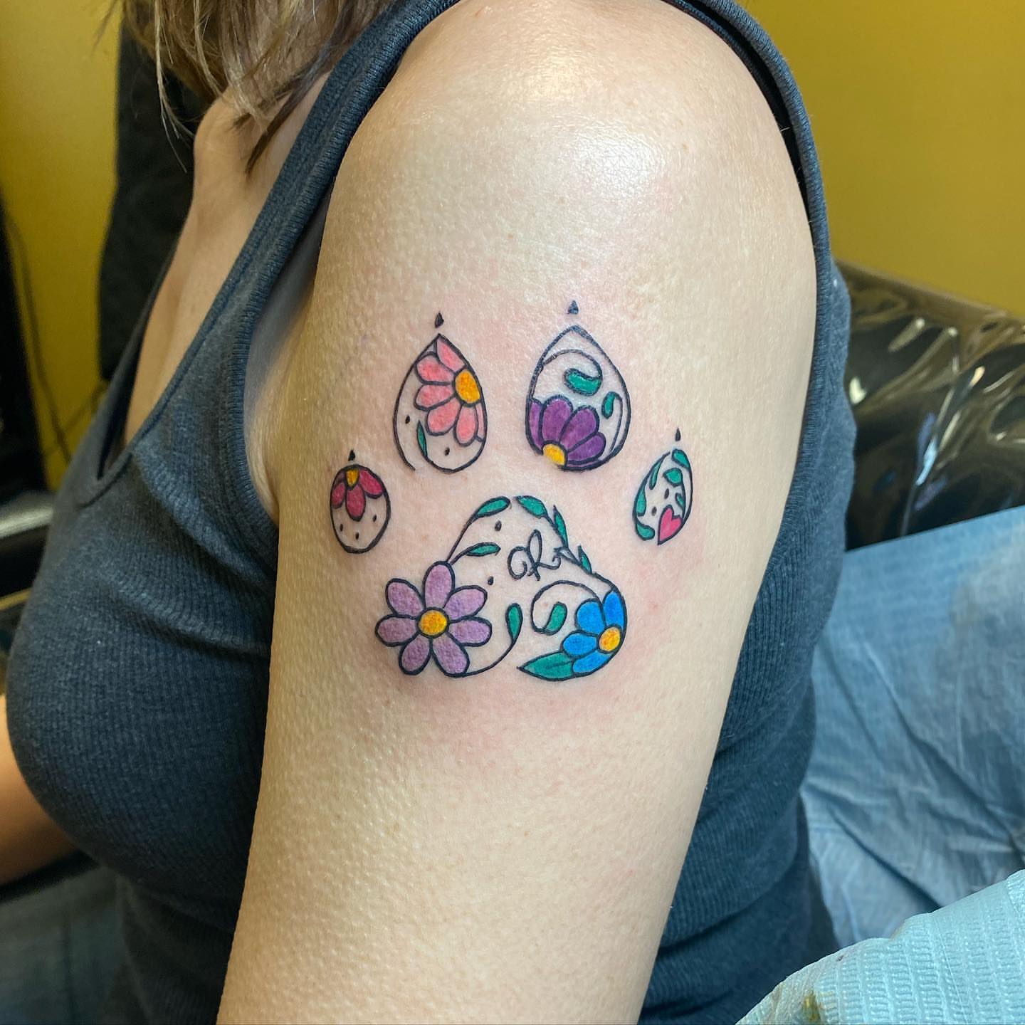 Floral paw print new school tattoo on the shoulder by Sally Darling