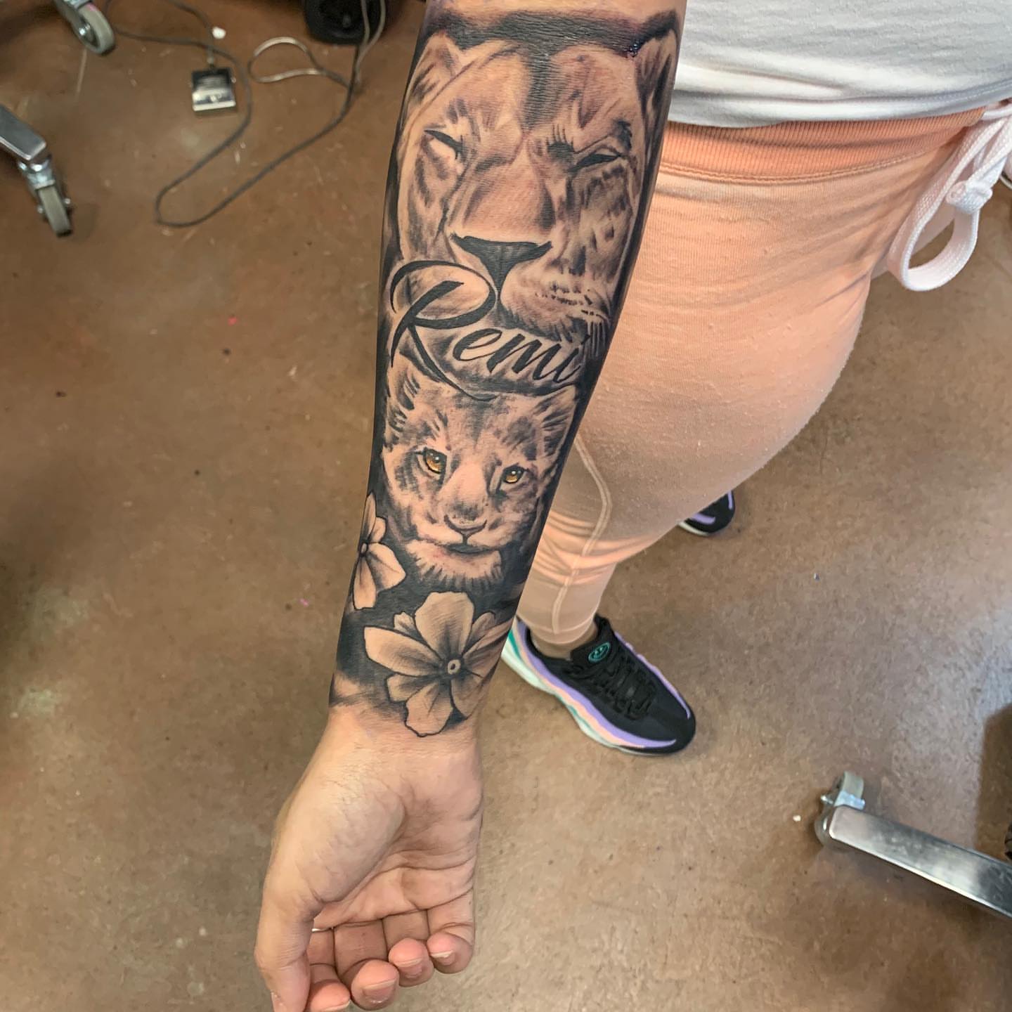 Lion and flowers realism tattoo on the forearm by Mikeyftsk2