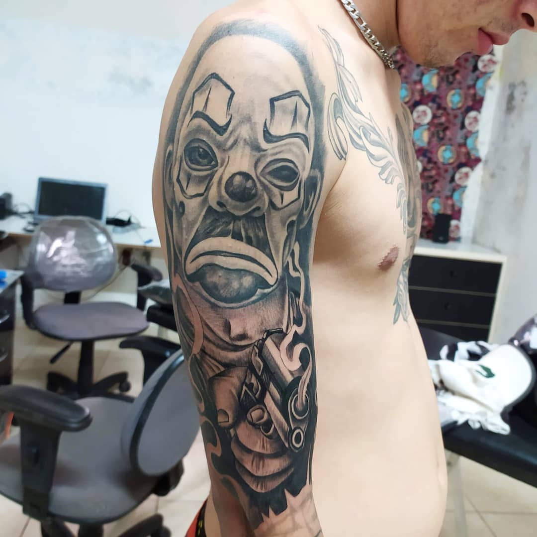 Clown mask with gun realism tattoo on the forearm by Marquin π§π·