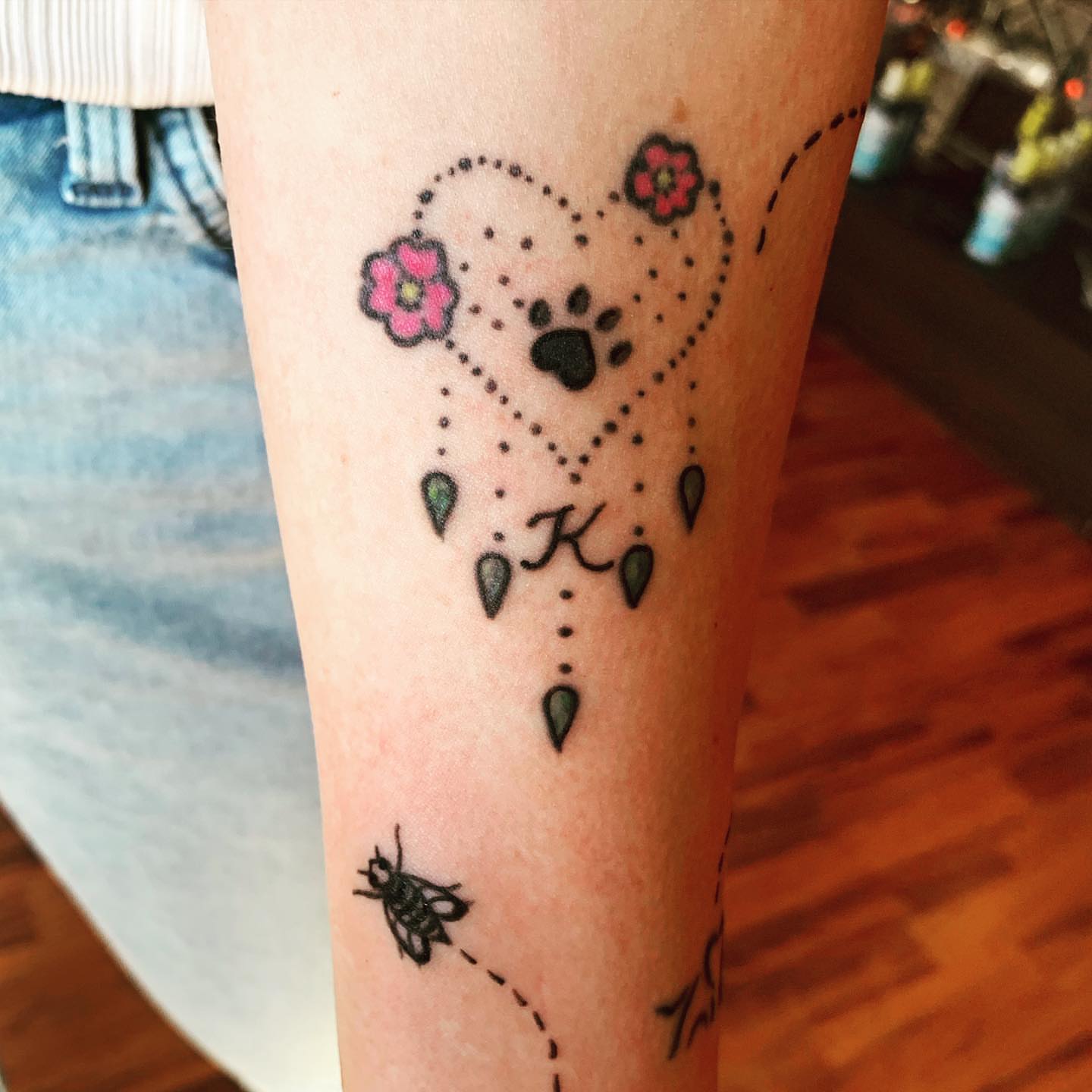 Dog paw print with flowers dotwork tattoo on the forearm by Rhonda Faber Green