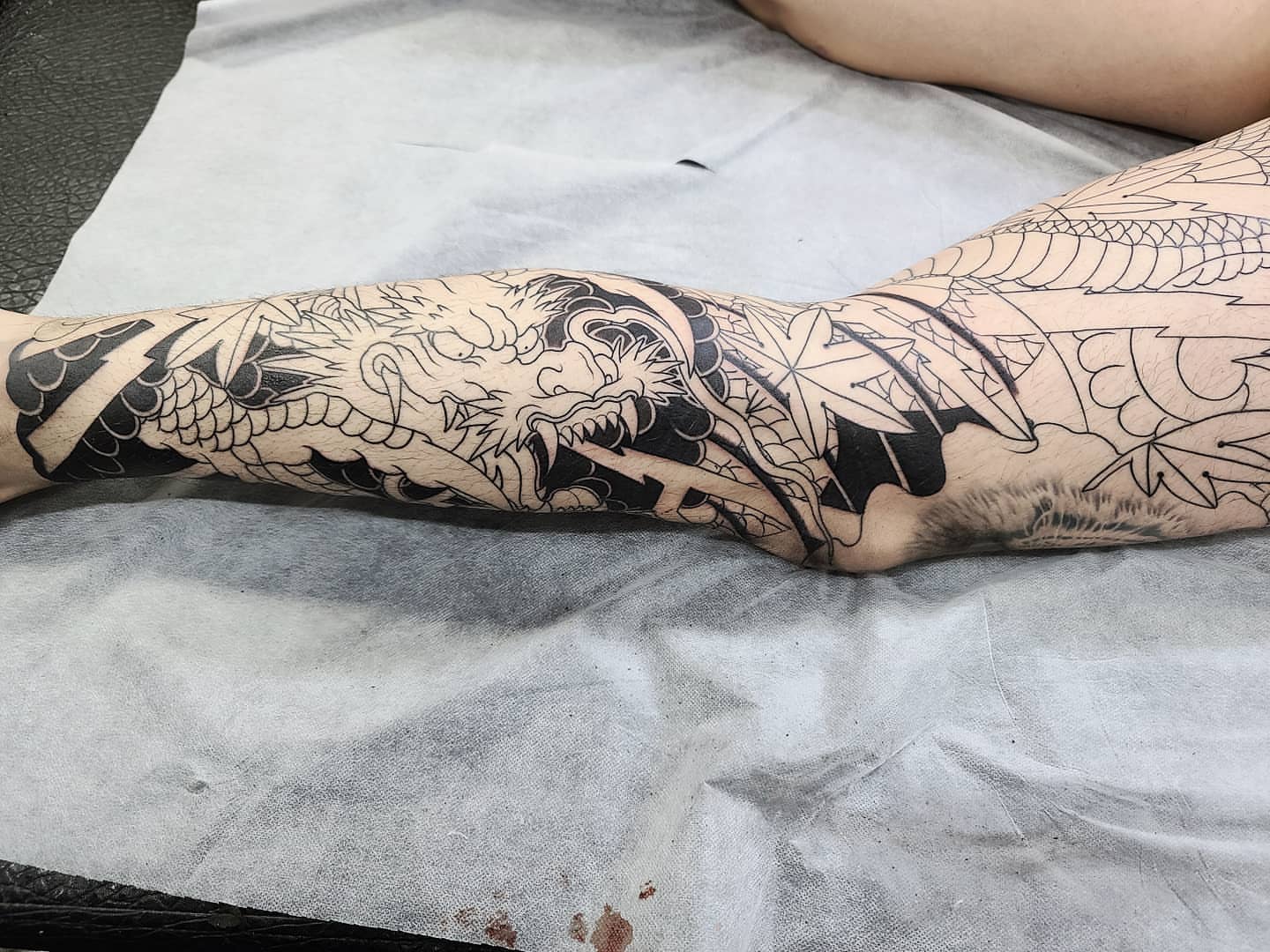 Dragon and leaves geometric tattoo on the forearm by CHUN (Chungyu Seong)