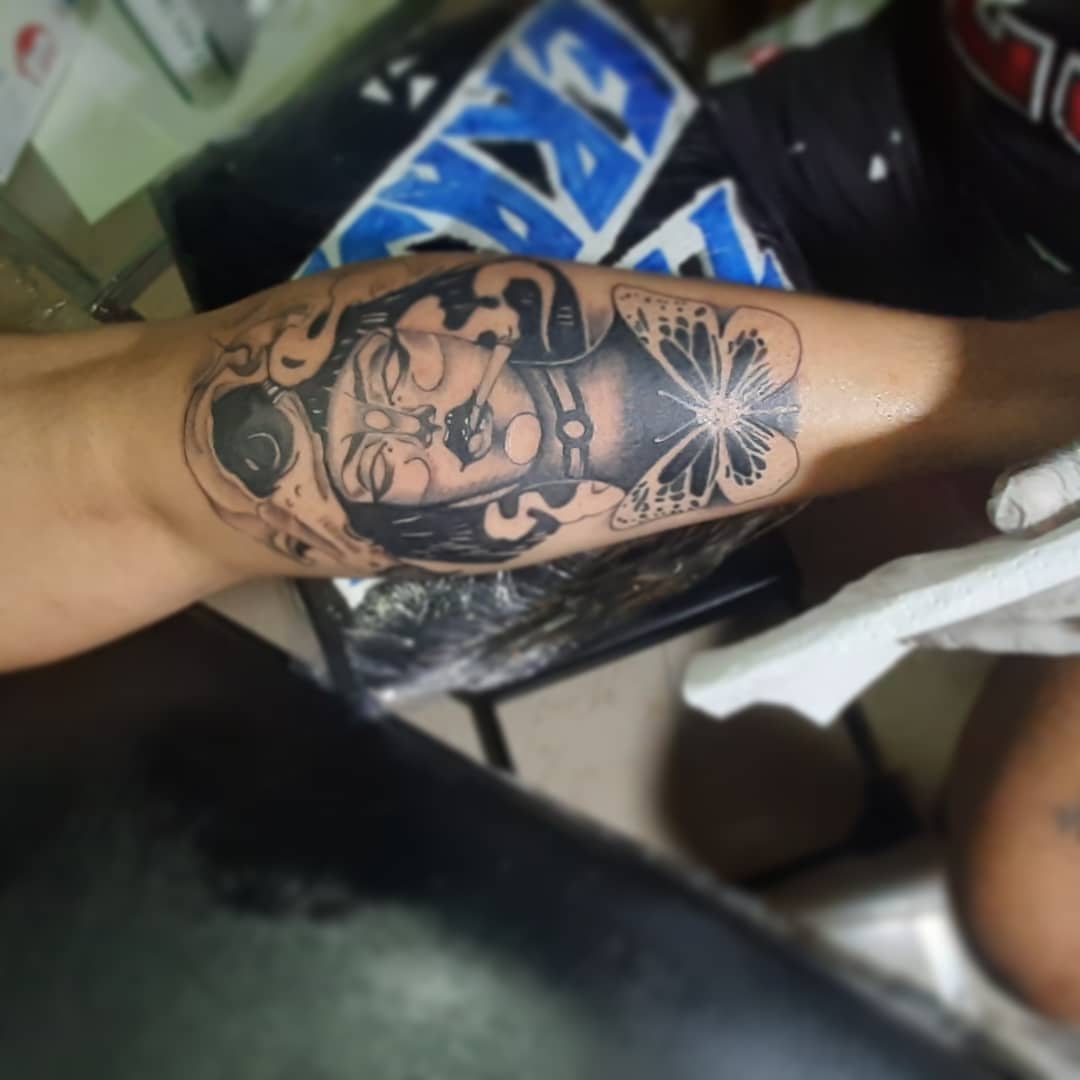 Bearded man with flower American traditional tattoo on the forearm by Erasmo Vasquez