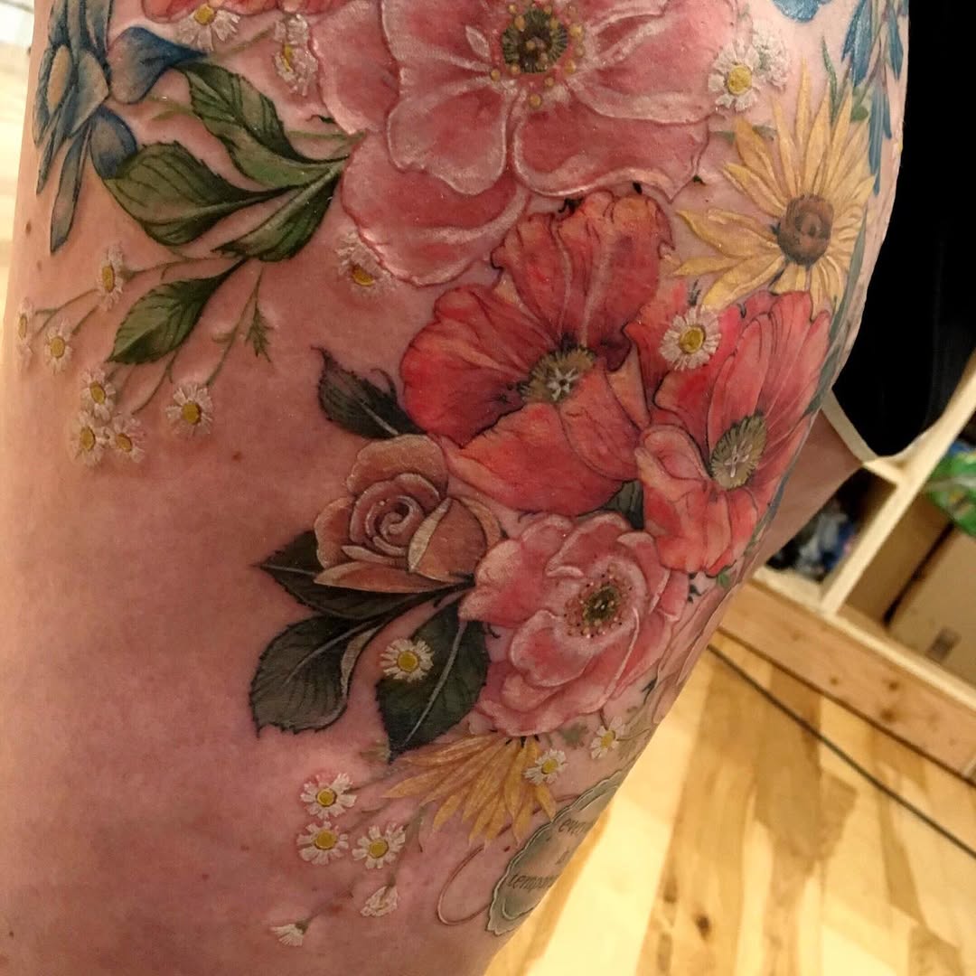 Floral arrangement neo-traditional tattoo on the thigh by Rachel Walker