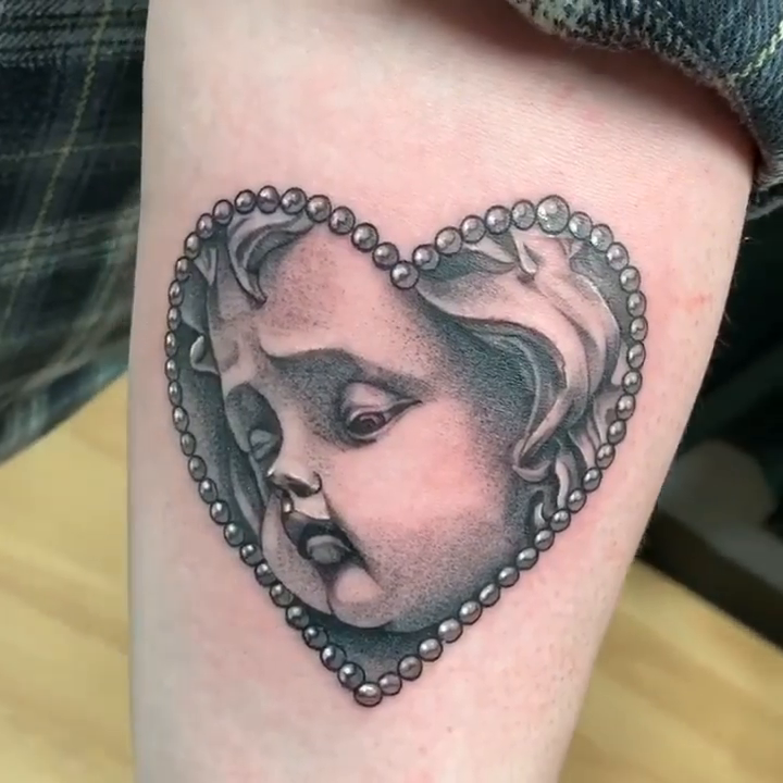 Cherub face in heart realism tattoo by Adrian Dominguez, Las Vegas, Nevada