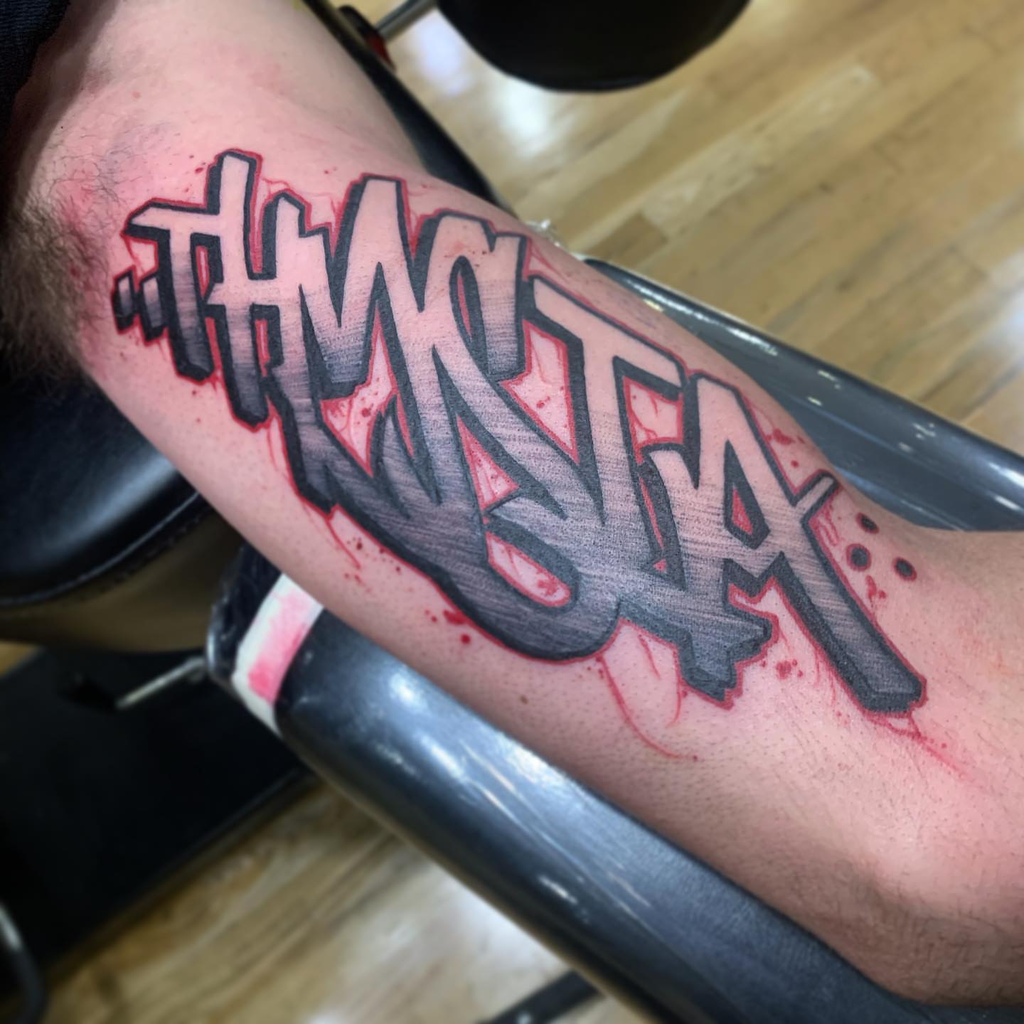 THWNK TAX lettering script tattoo on the forearm by Ben Viamontes