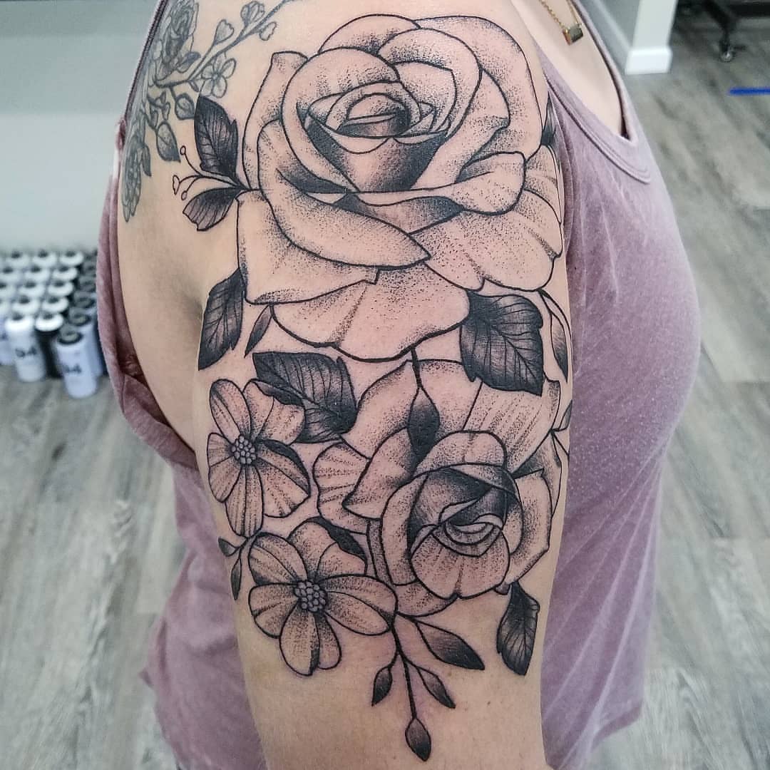Floral bouquet dotwork tattoo on the upper arm by Dick Eckman