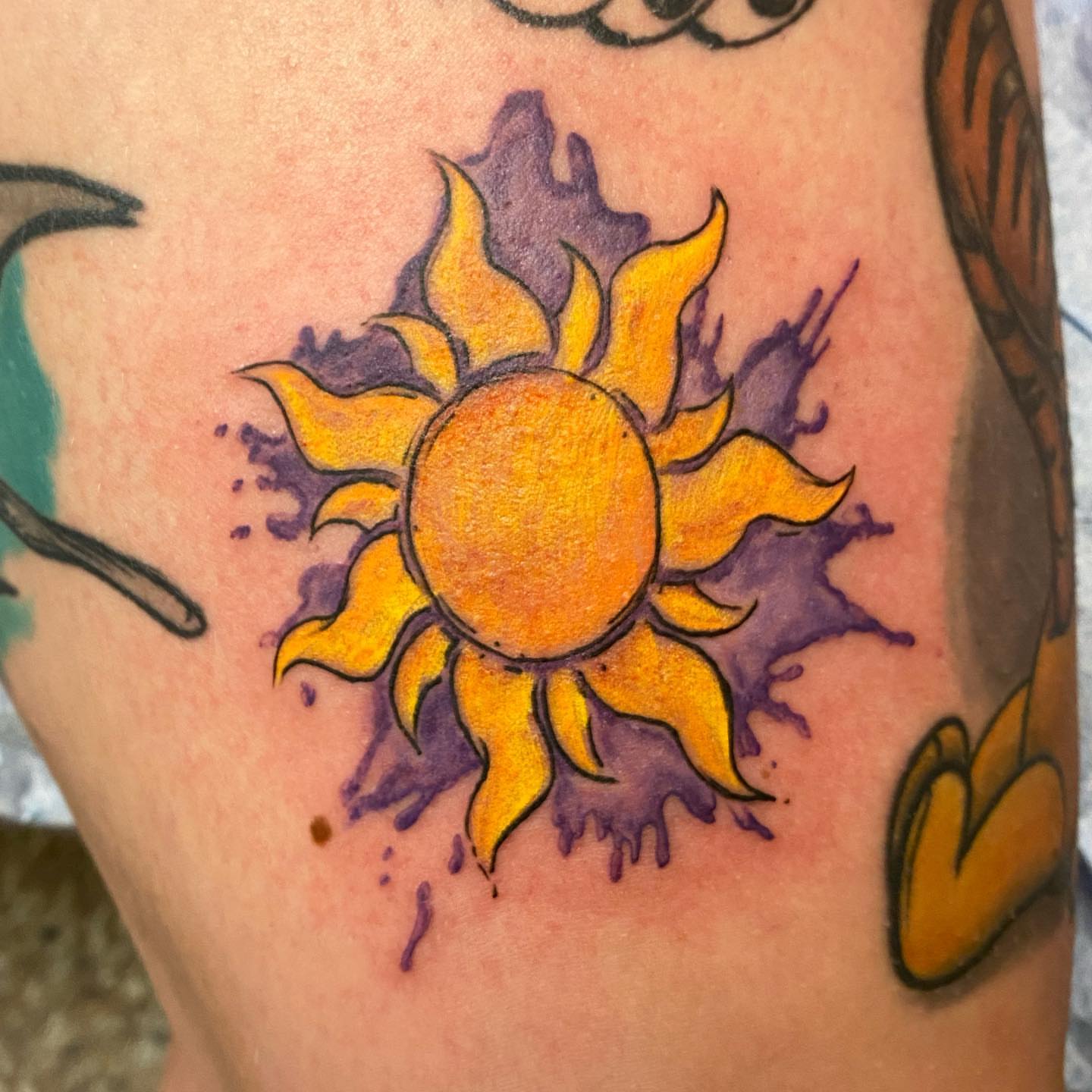 Sun watercolor tattoo on the forearm by Sally Darling