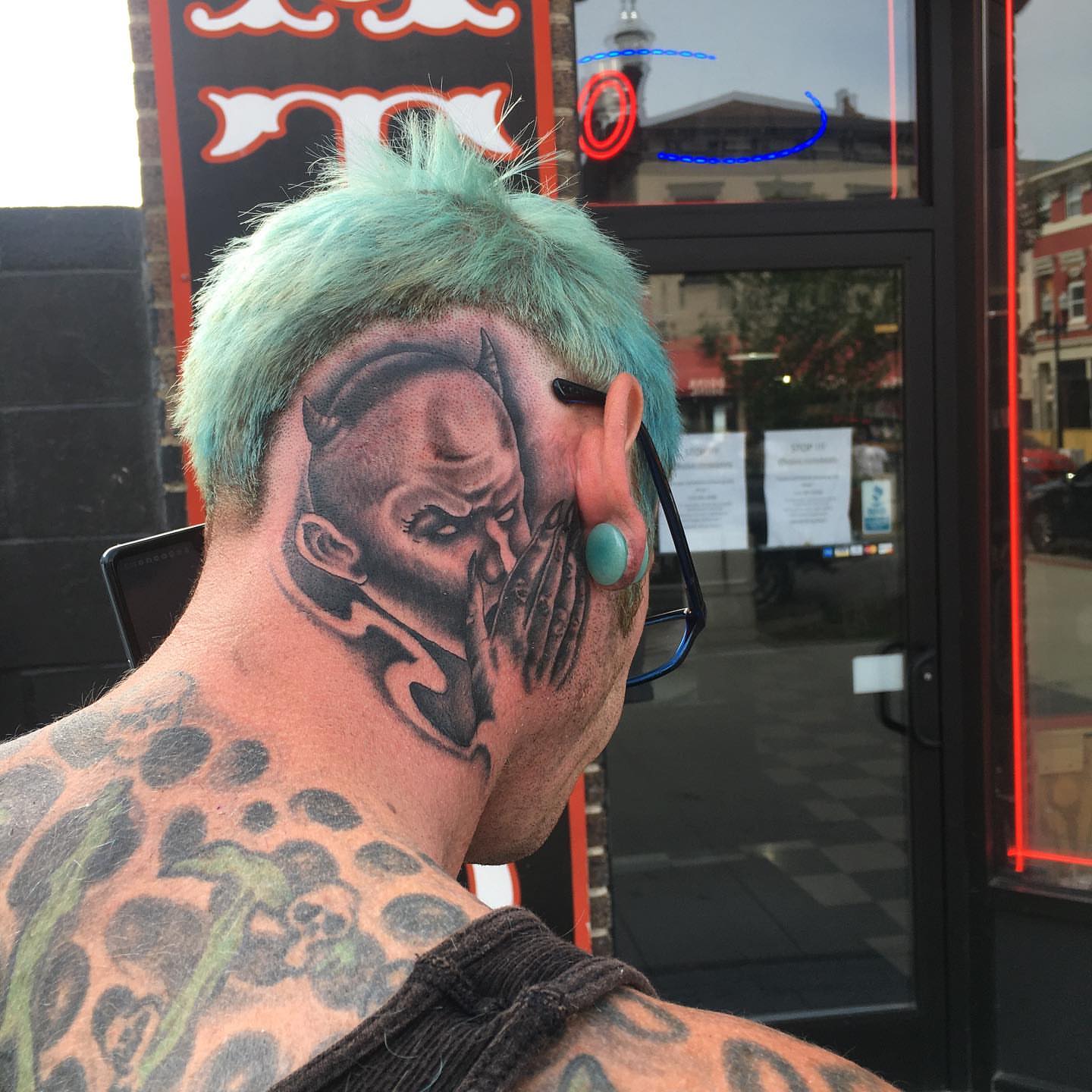 Man with blue hair black and grey tattoo on the neck by Brian Keith