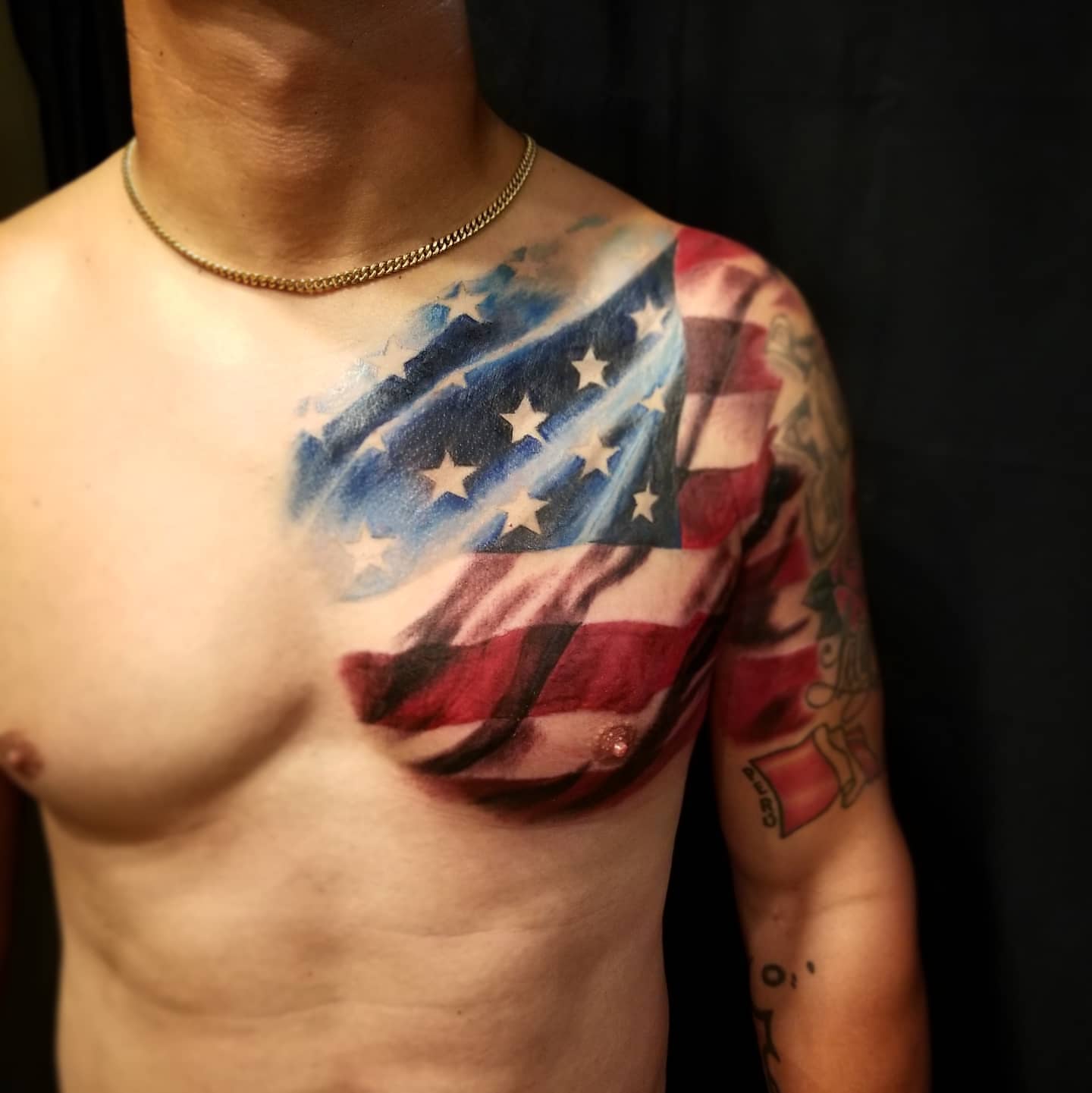 American flag realism tattoo on the chest by Neil Ohmie