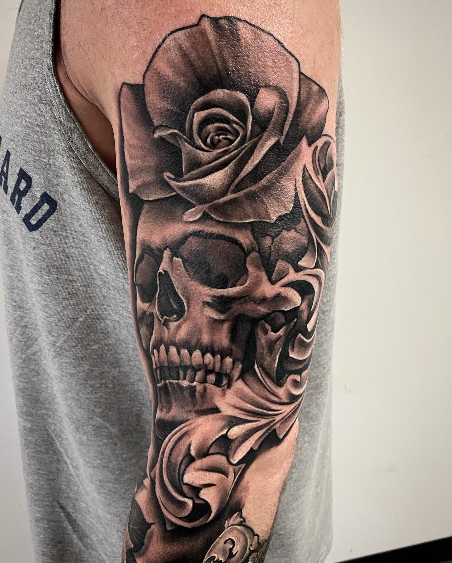 Rose and skull realism tattoo on the forearm by Dale DeVille