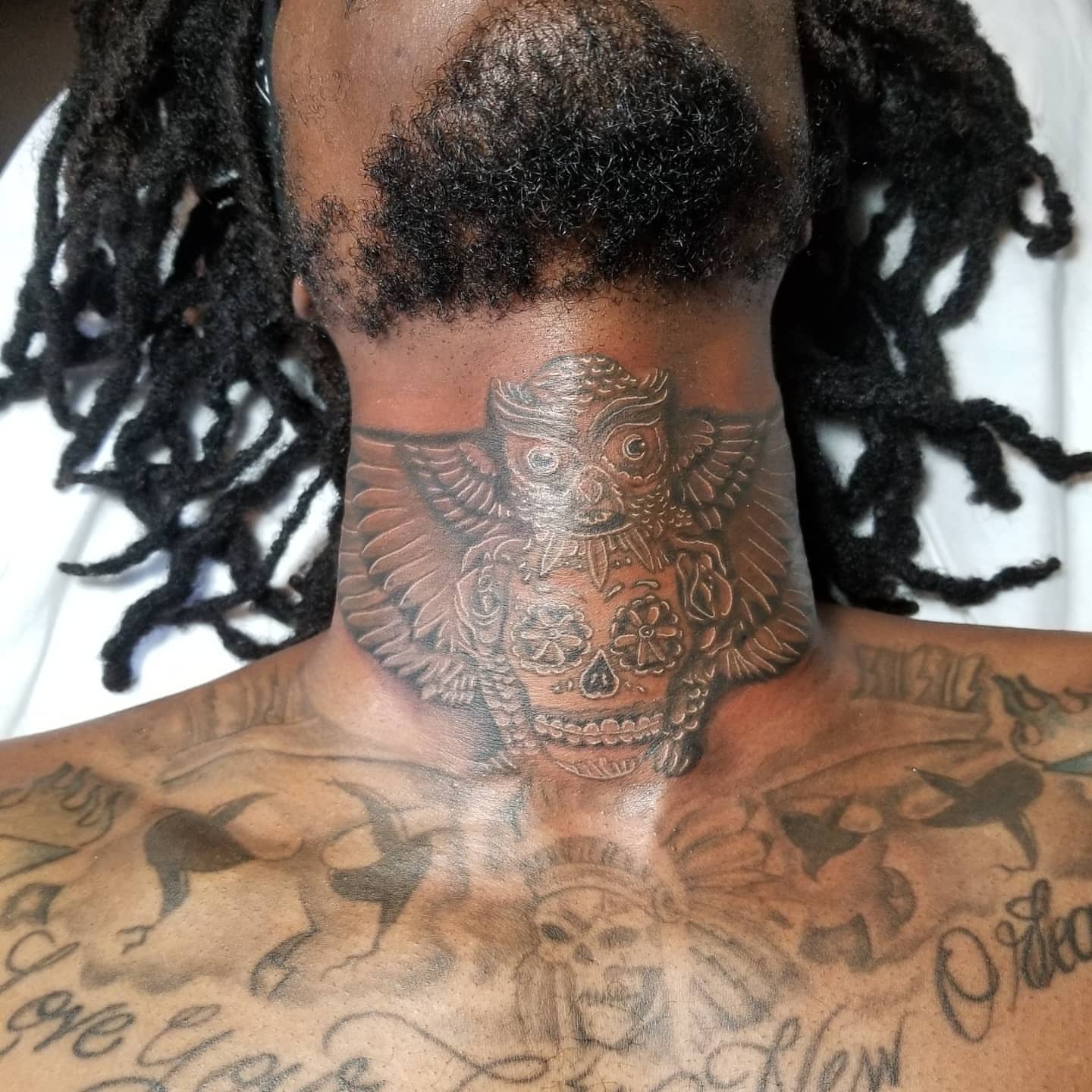 Skull with wings black and grey tattoo on the neck by Miguel-C, Houston, Texas