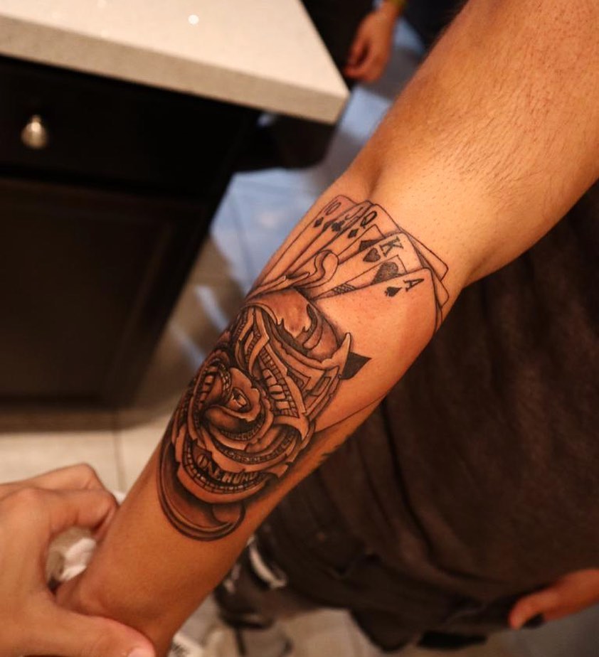Rose and playing cards realism tattoo on the forearm by Kevin Palma