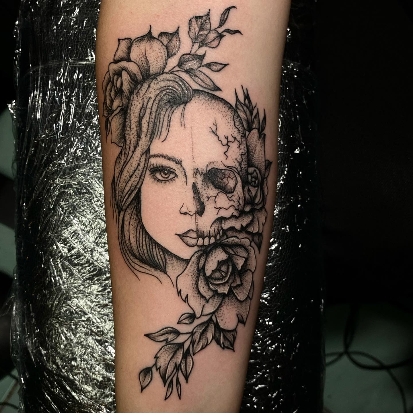 Woman with skull dotwork tattoo on the forearm by Syd Cheyenne