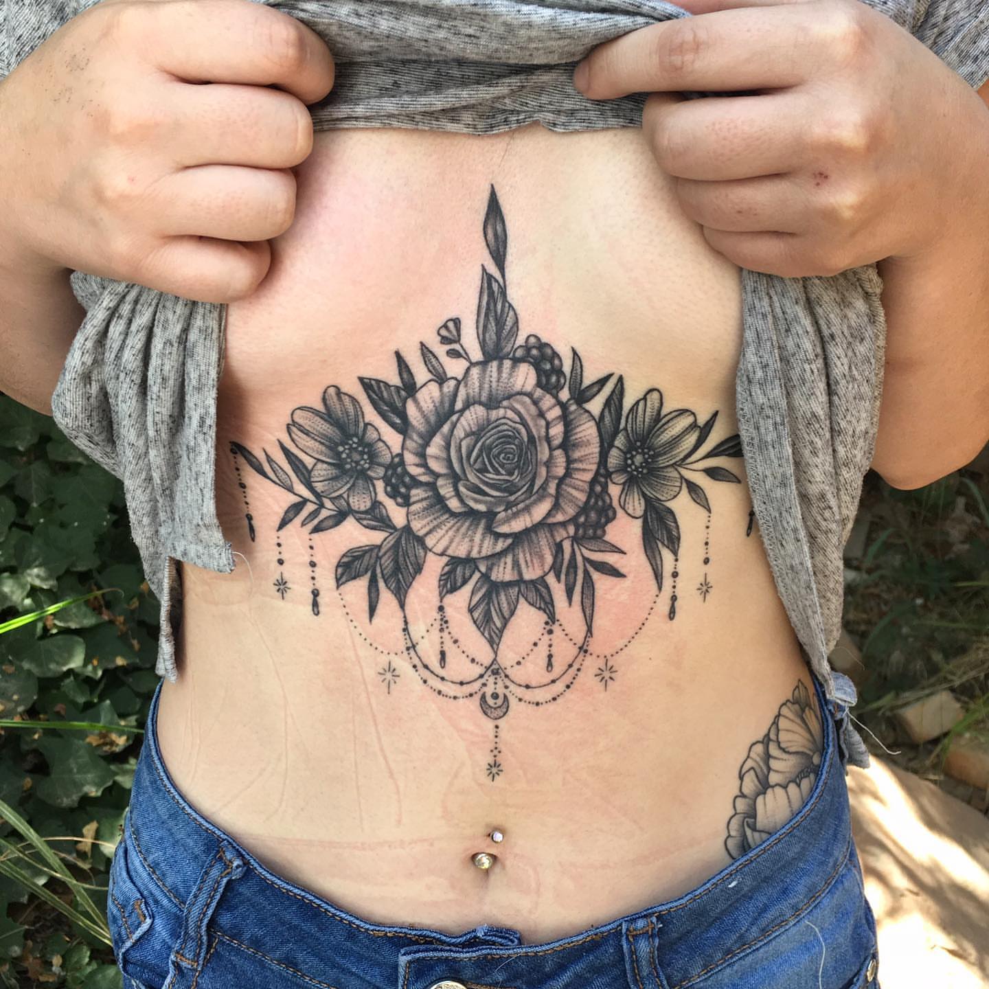 Floral bouquet black and grey tattoo on the ribs by Ray Marie