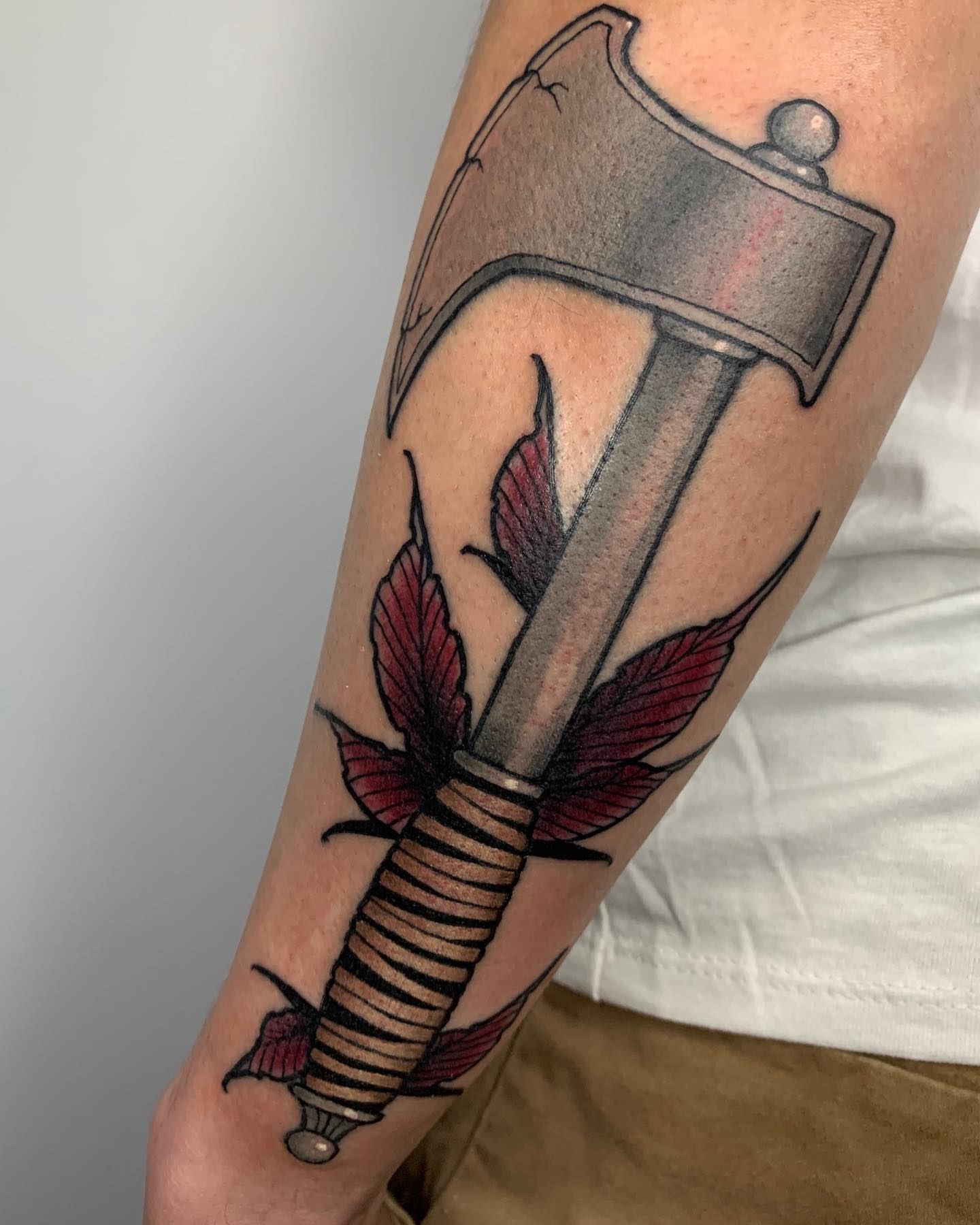 Ax and feathers American traditional tattoo on the forearm by Luis Torres, Harrison, New Jersey