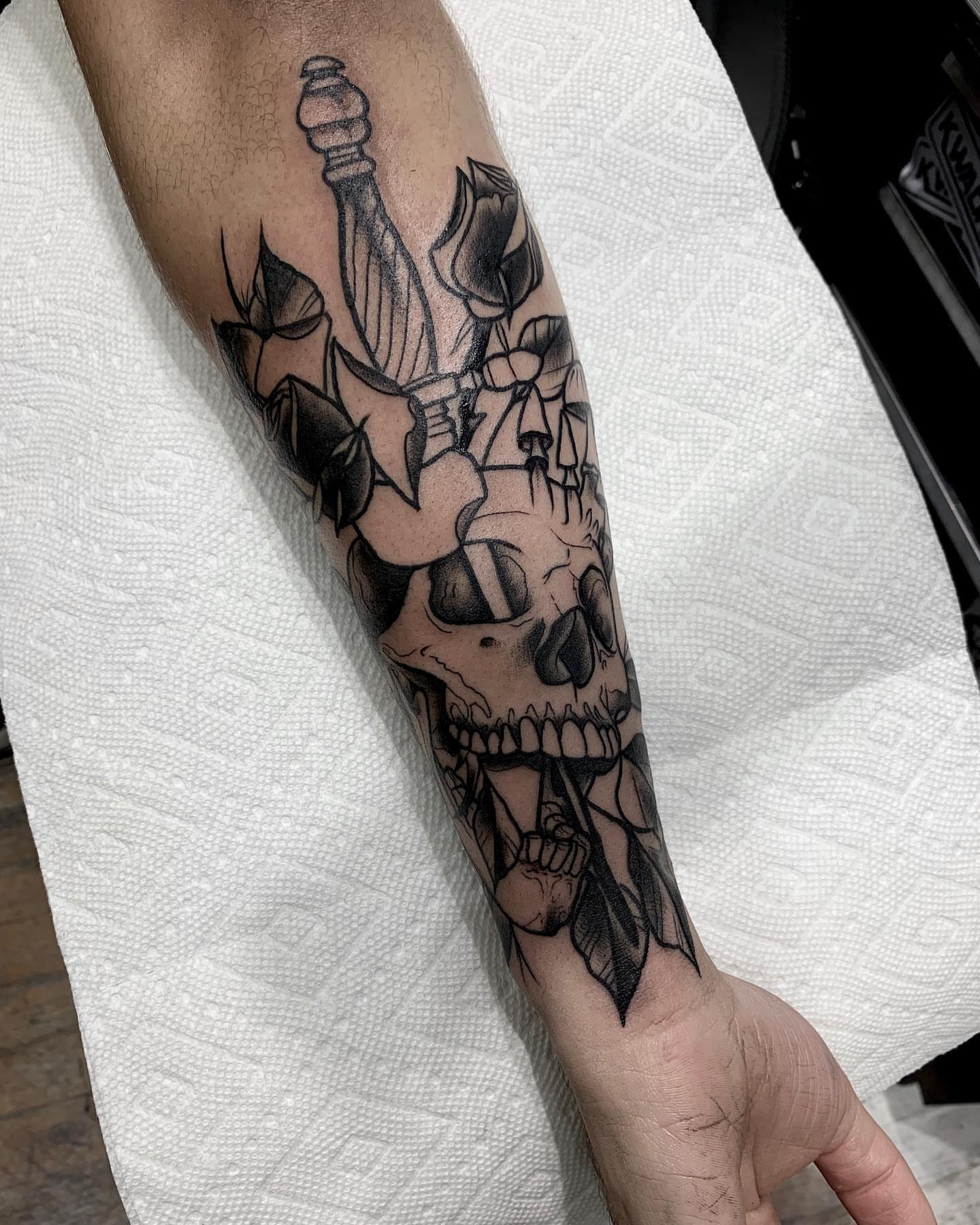 Skull and roses realism tattoo on the forearm by E