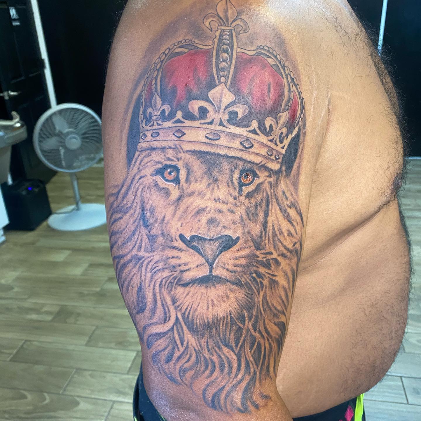 Lion with crown realism tattoo on the shoulder by pecous