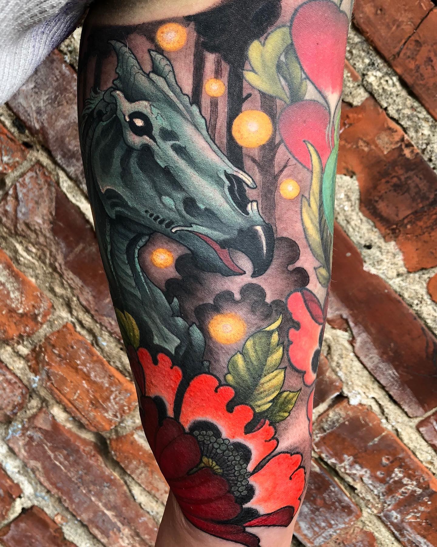 Dragon and flowers American traditional tattoo on the forearm by Erin Chance