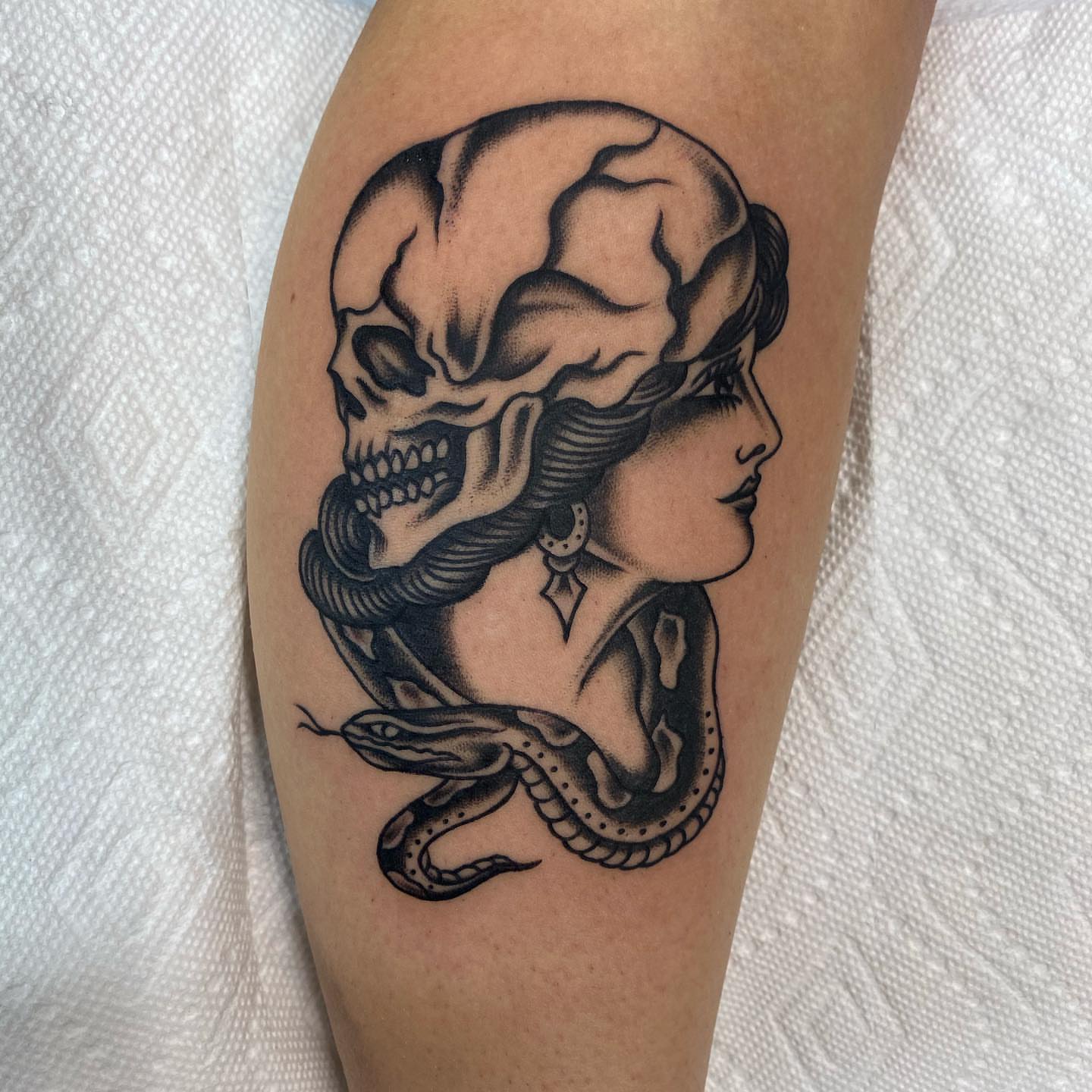 Woman with snake black and grey tattoo on the forearm by Dave G
