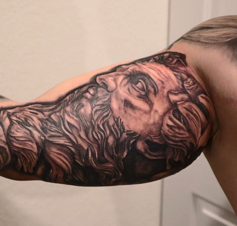 Lion black and grey tattoo on the shoulder by Kevin Palma