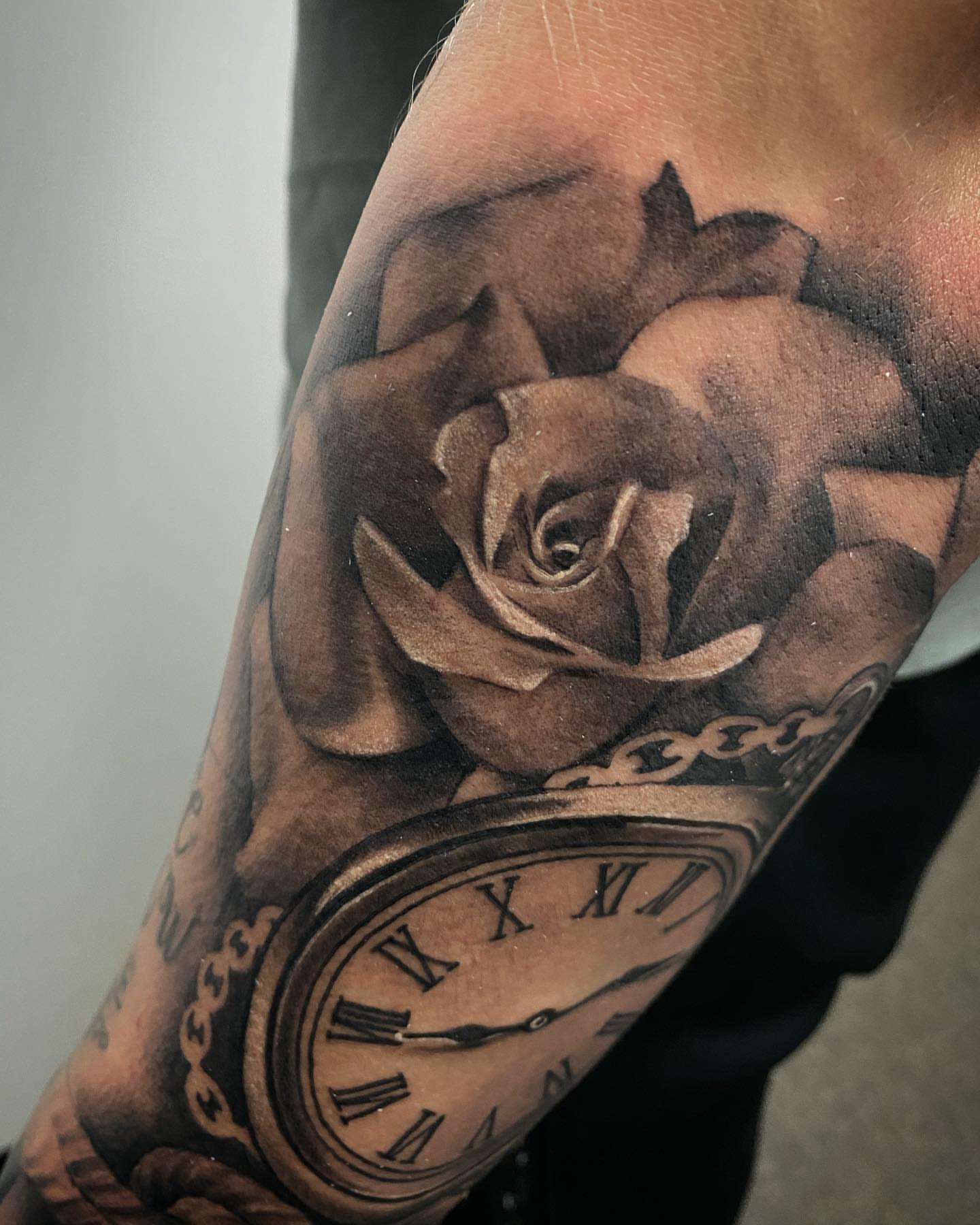 Rose and clock realism tattoo on the forearm by Dale DeVille