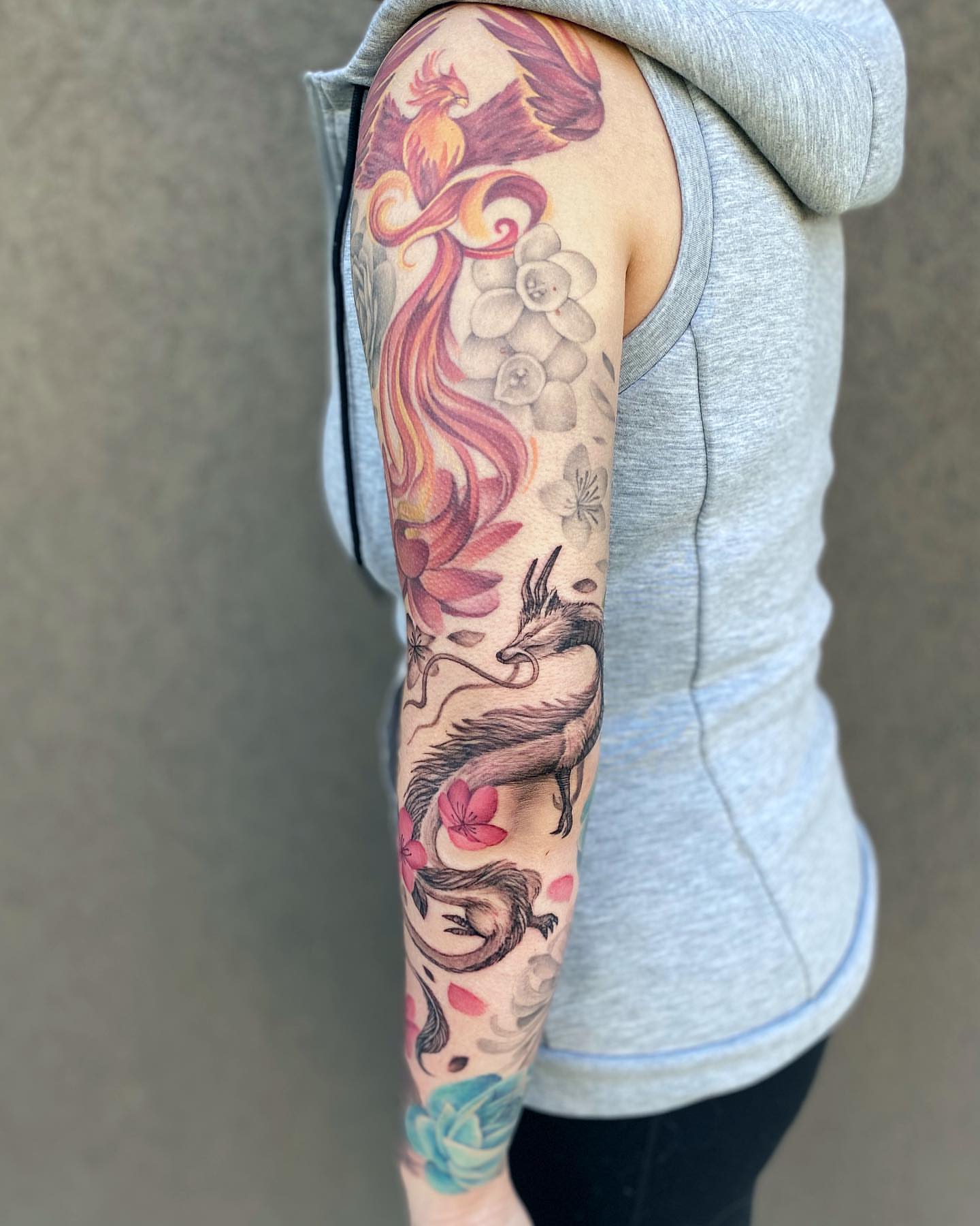 Phoenix and dragon dotwork tattoo on the forearm by Jax Citriglia