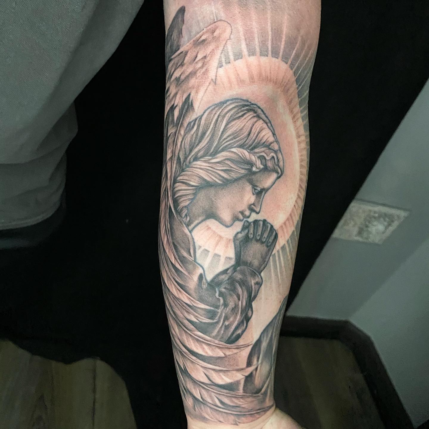 Praying angel realism tattoo on the forearm by Dustin Lane Collins