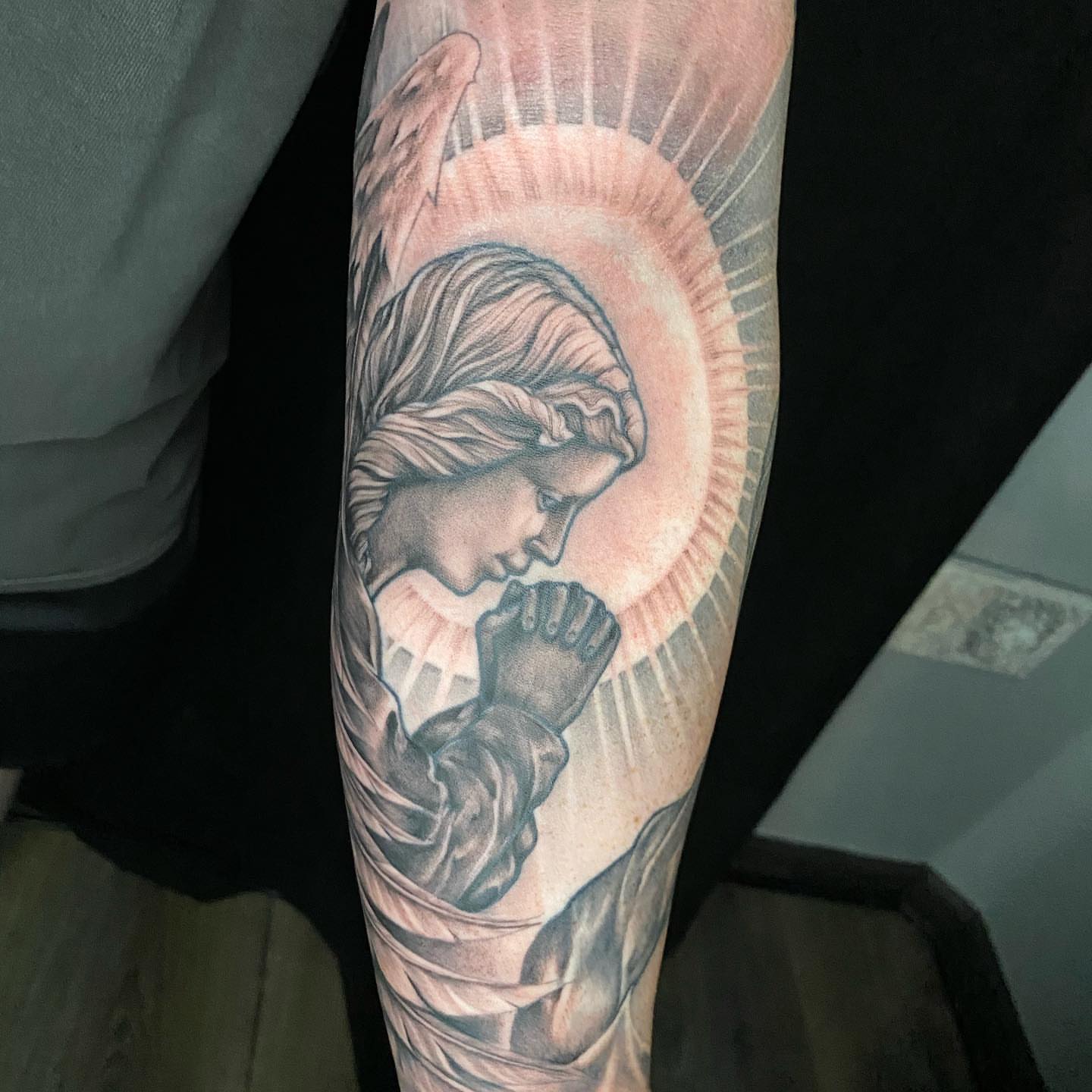 Praying angel realism tattoo on the forearm by Dustin Lane Collins