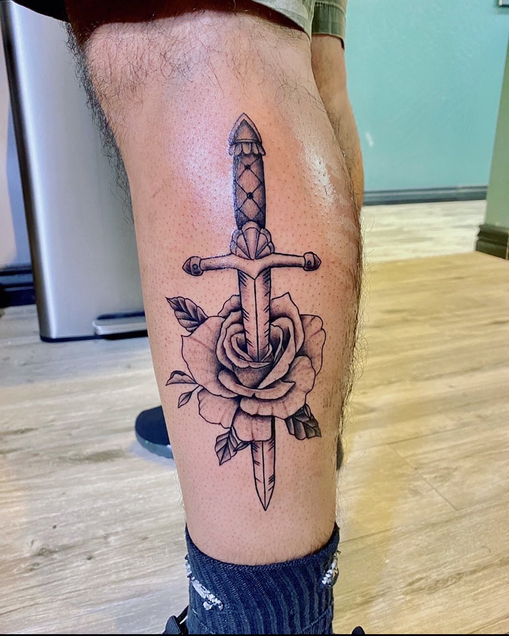 Sword through rose black and grey tattoo on the thigh by Monique Ortiz, Mesa, Arizona