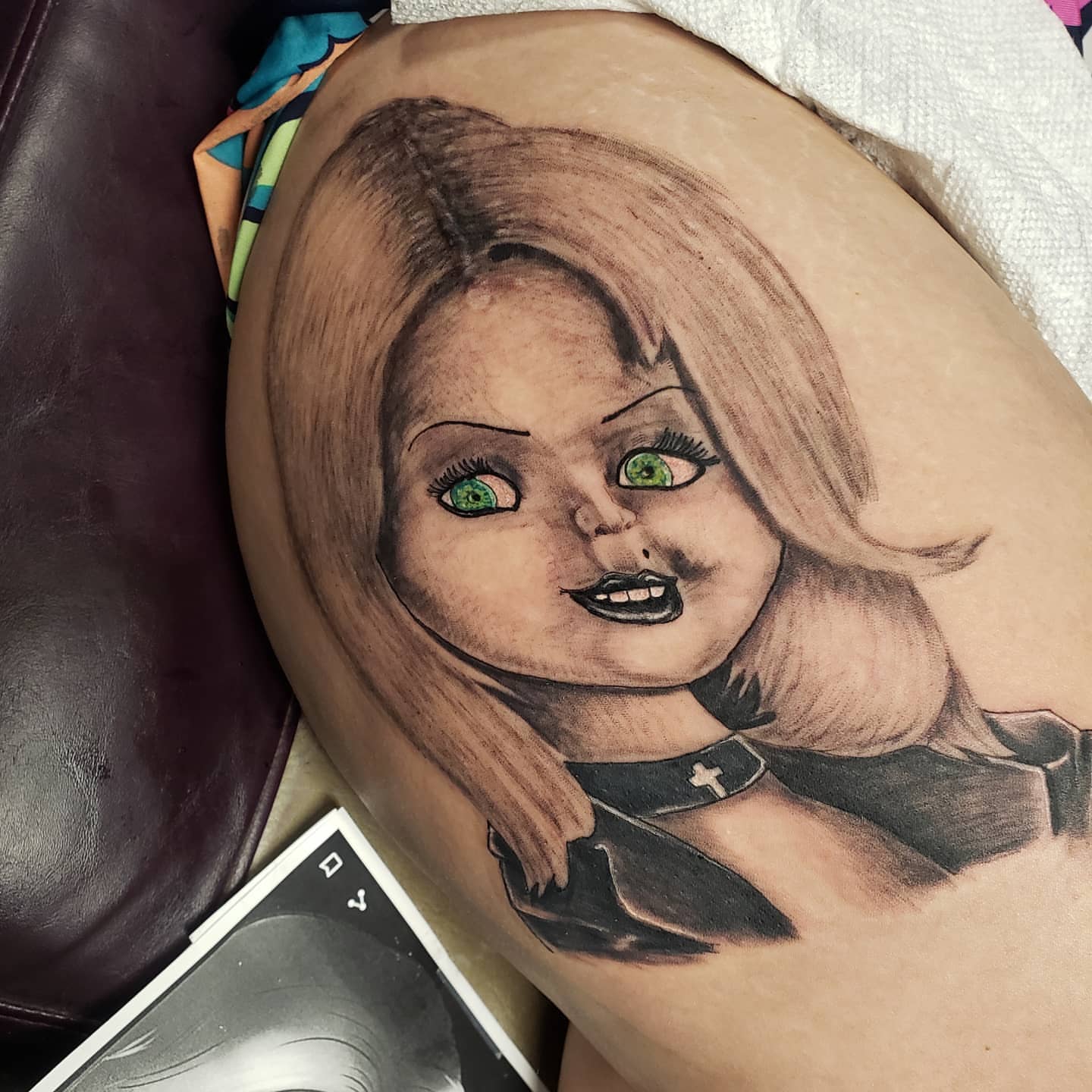 Doll realism tattoo on the thigh by Glen Wallis