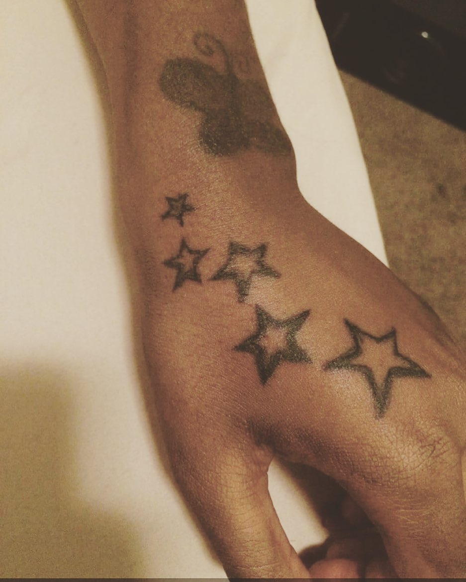 Five-pointed stars black and grey tattoo on the forearm by Danimals