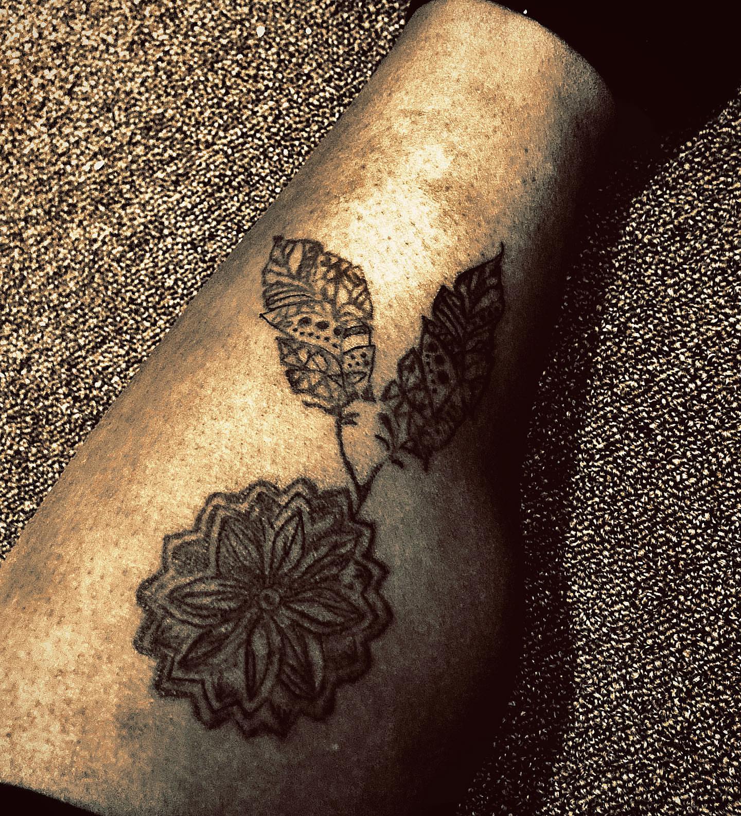 Floral and feather design black and grey tattoo on the forearm by Danimals