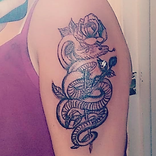 Snake and rose black and grey tattoo on the upper arm by Louie Vee Guddah