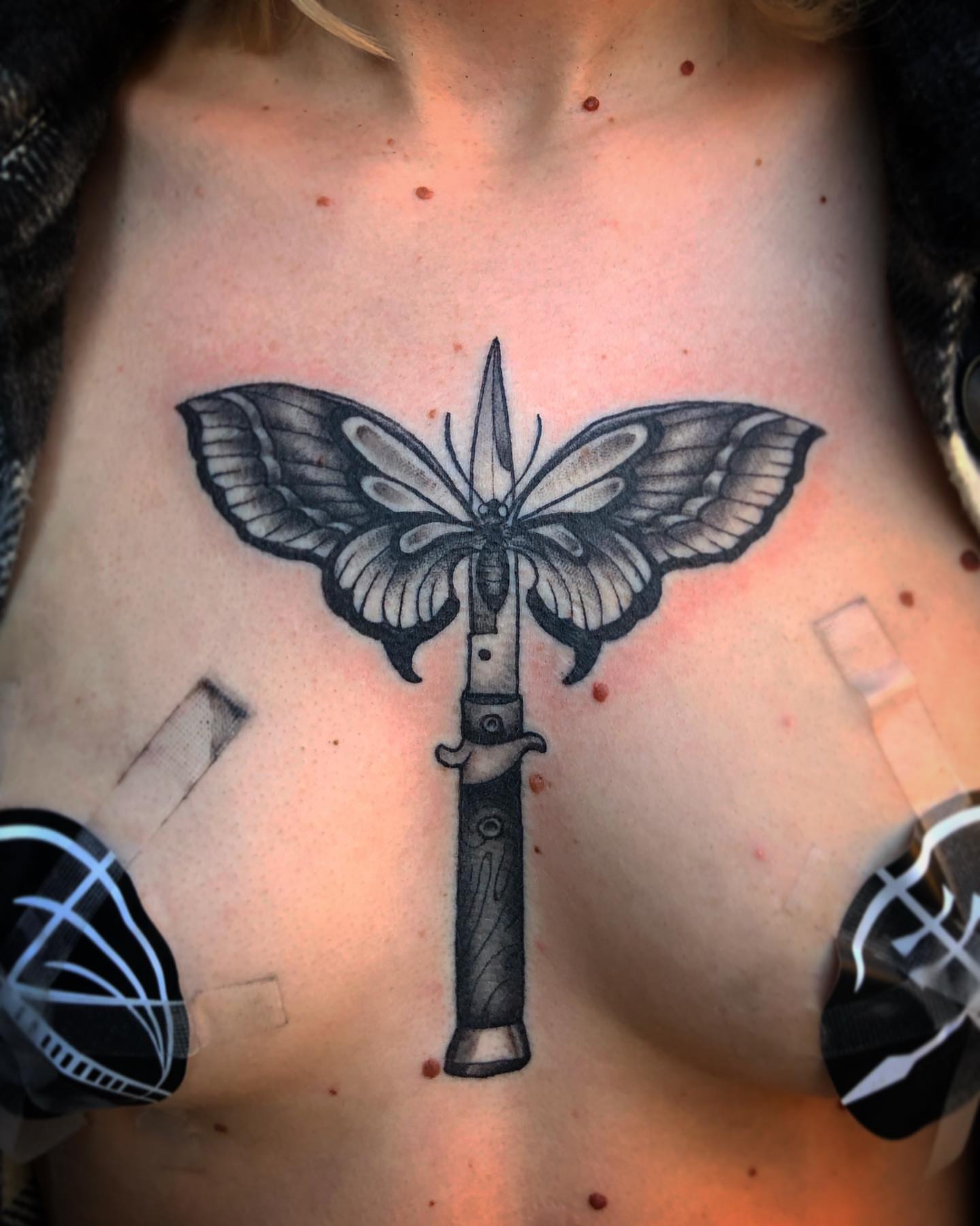 Moth and dagger geometric tattoo on the chest by Dave Shurman