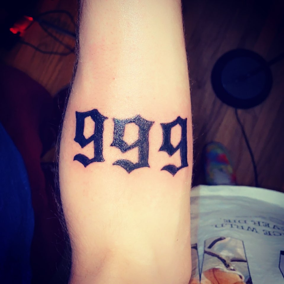 Number 999 lettering script tattoo on the forearm by Daniel Monyongo