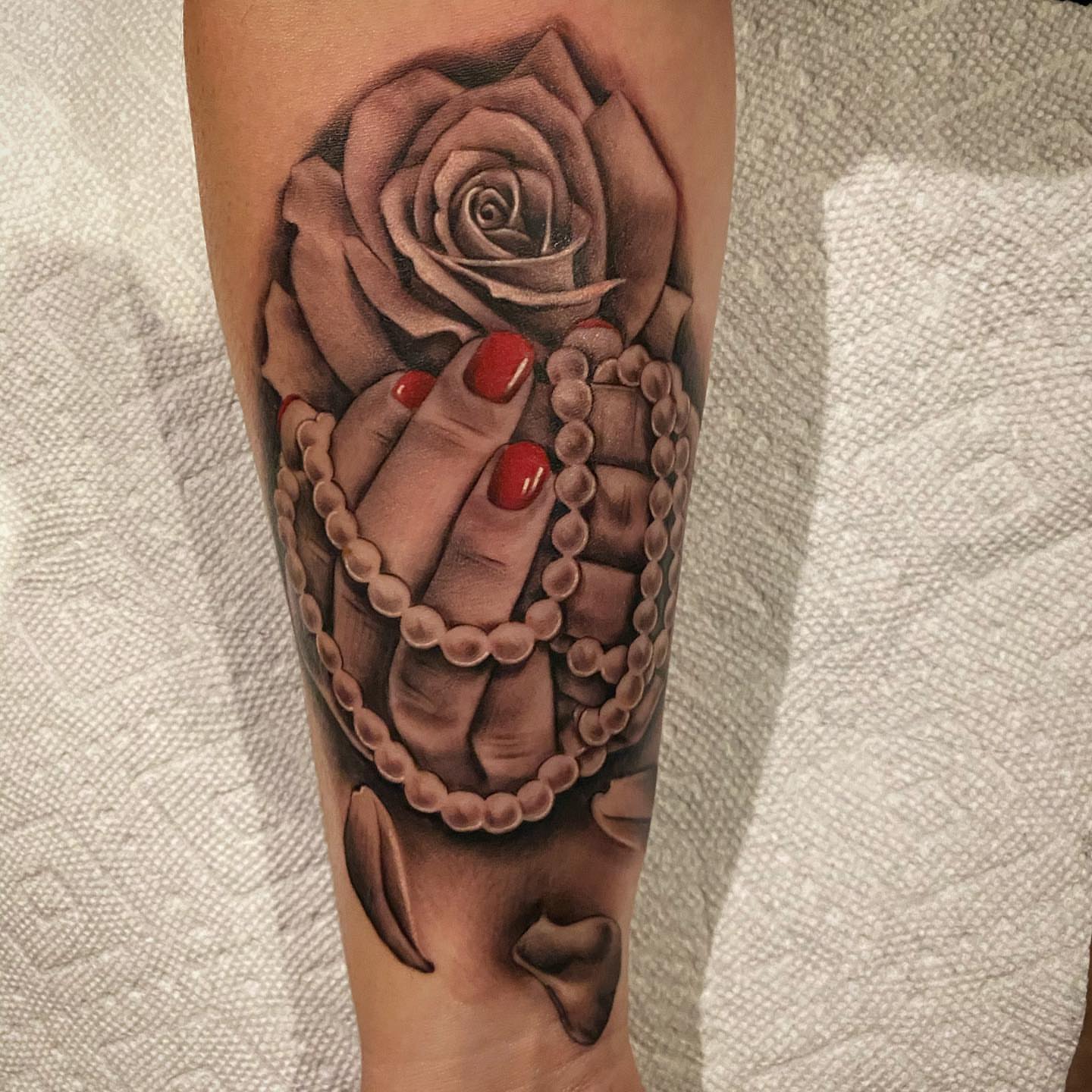 Rose and hand realism tattoo on the forearm by Dale DeVille