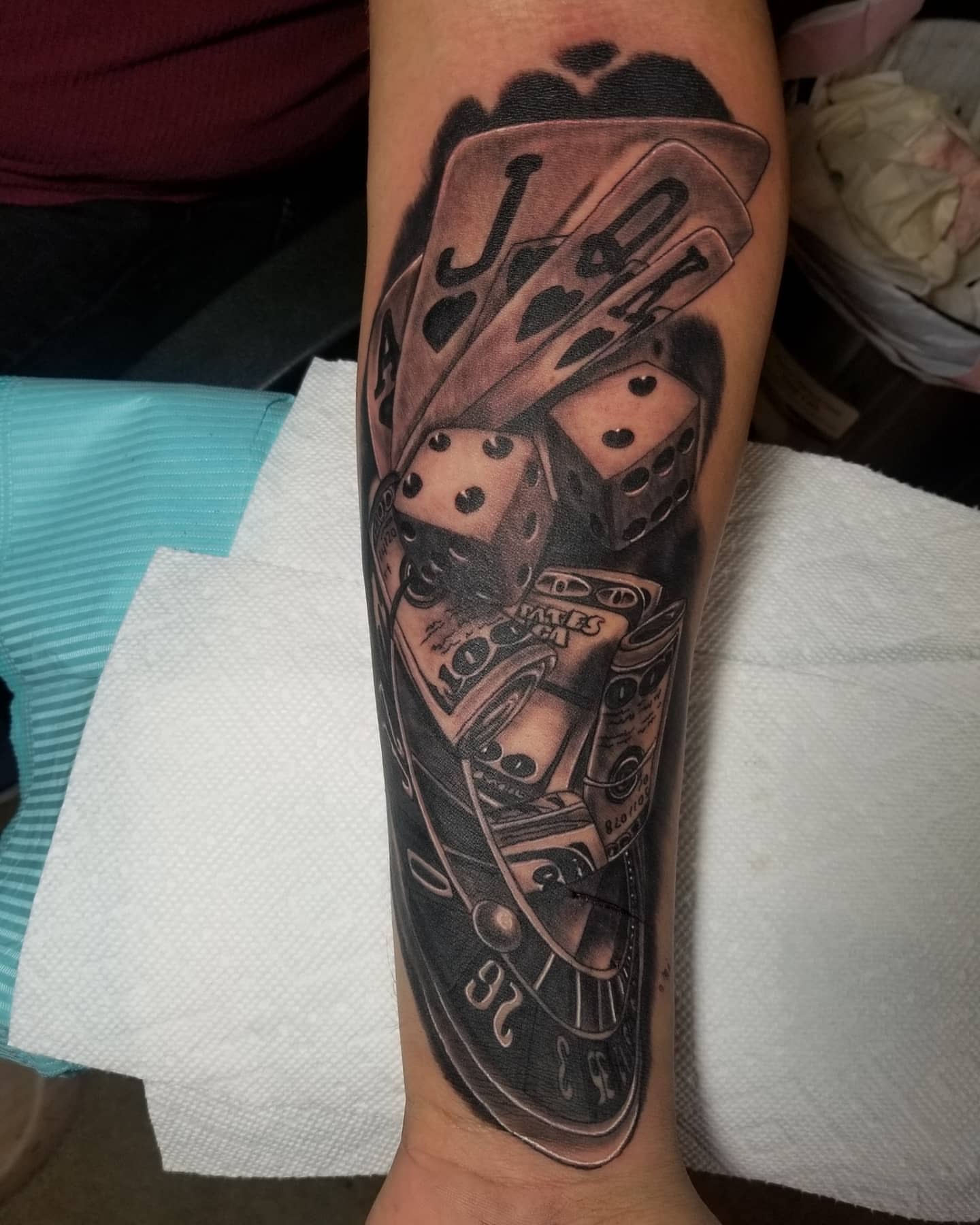 Playing cards and dice black and grey tattoo on the forearm by Miguel-C, Houston, Texas
