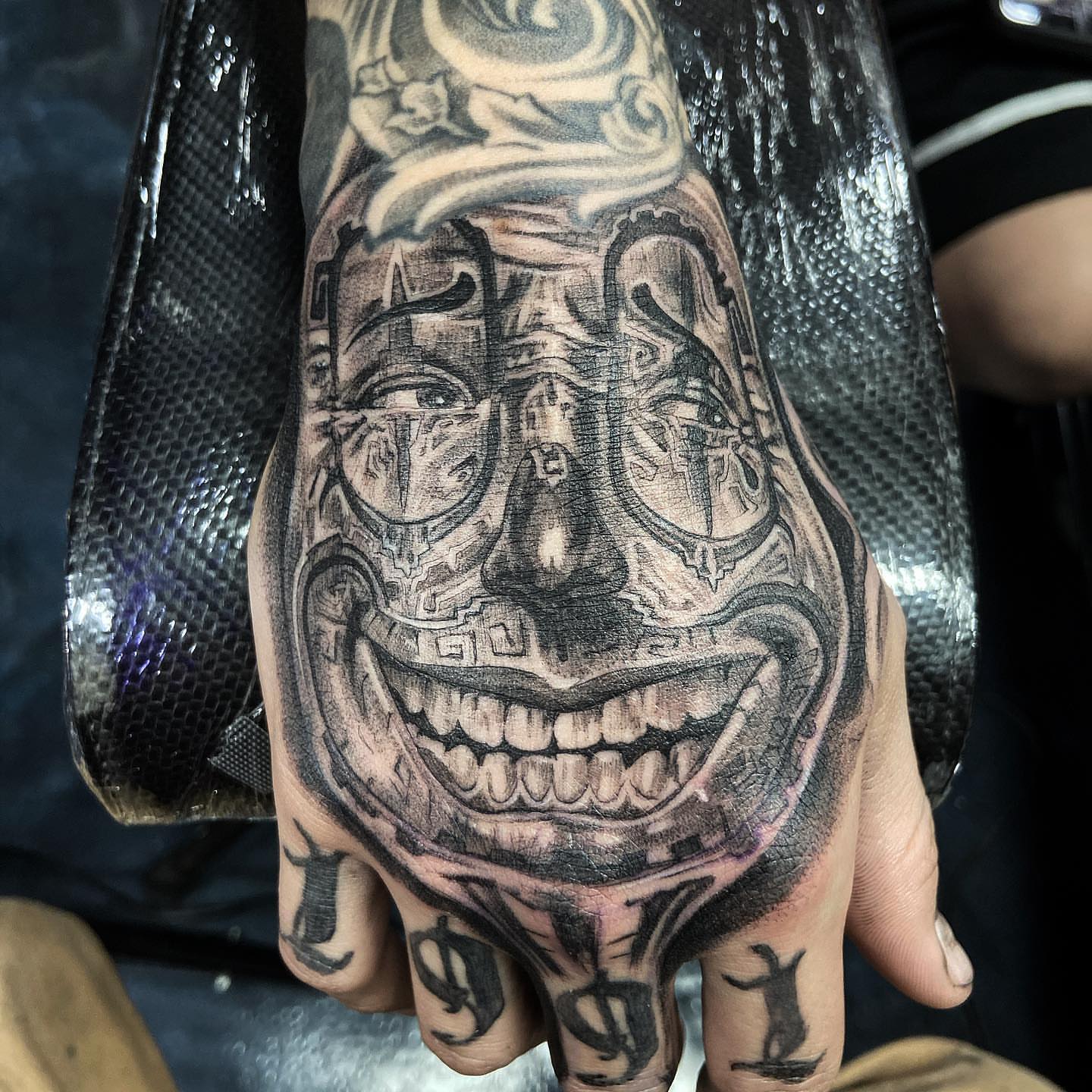 Smiling face realism tattoo on the hand by Creeper tattoo