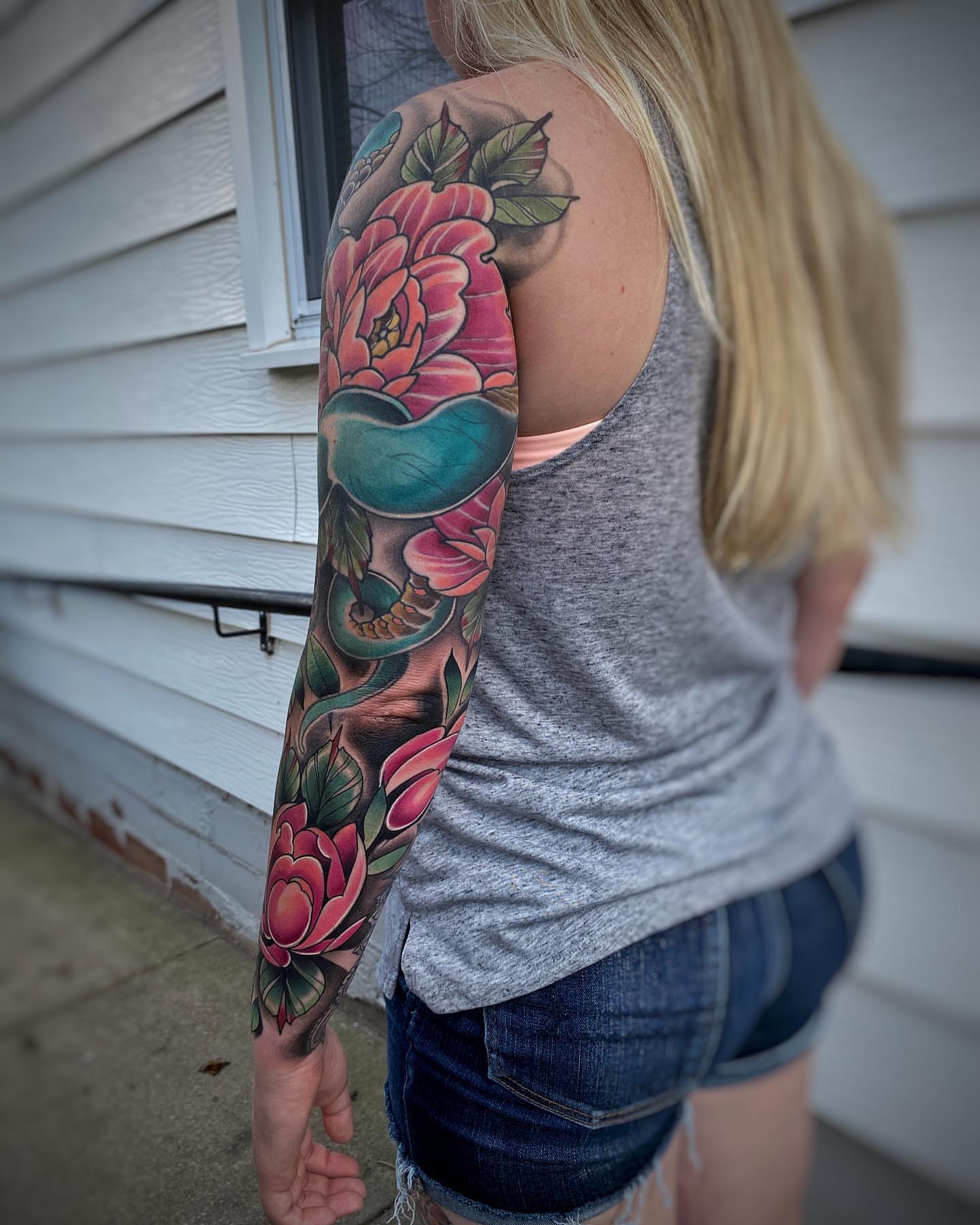Peony and skull realism tattoo on the upper arm by Derek Hutchison, Des Moines, Iowa