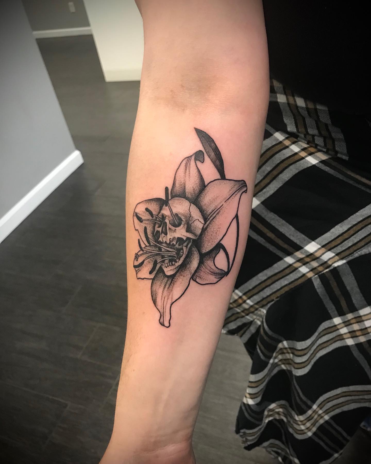 Lily with skull dotwork tattoo on the forearm by Christopher McGlone