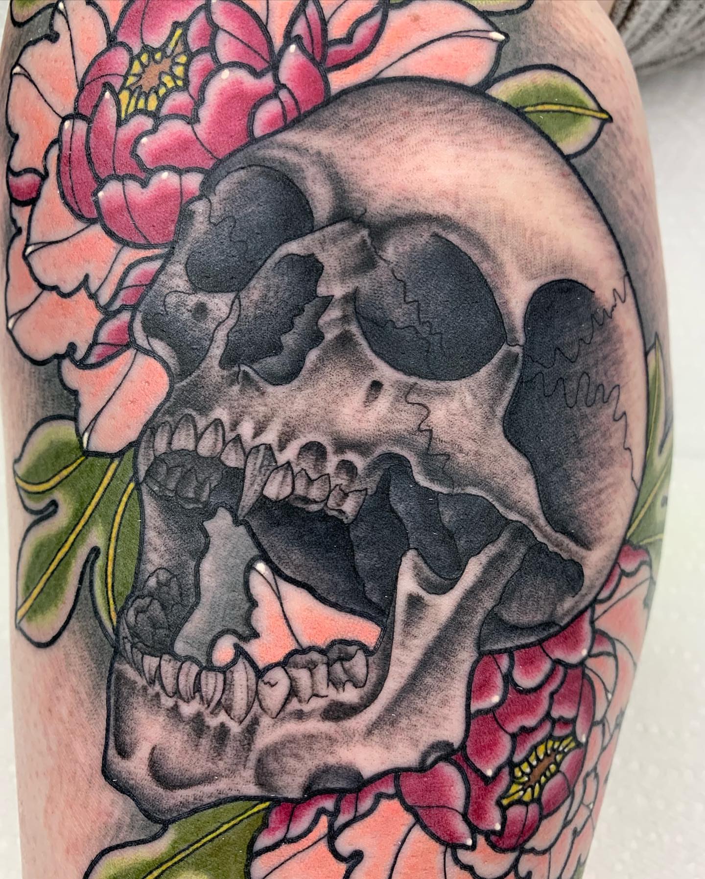 Skull and flowers American traditional tattoo on the forearm by Luis Torres, Harrison, New Jersey