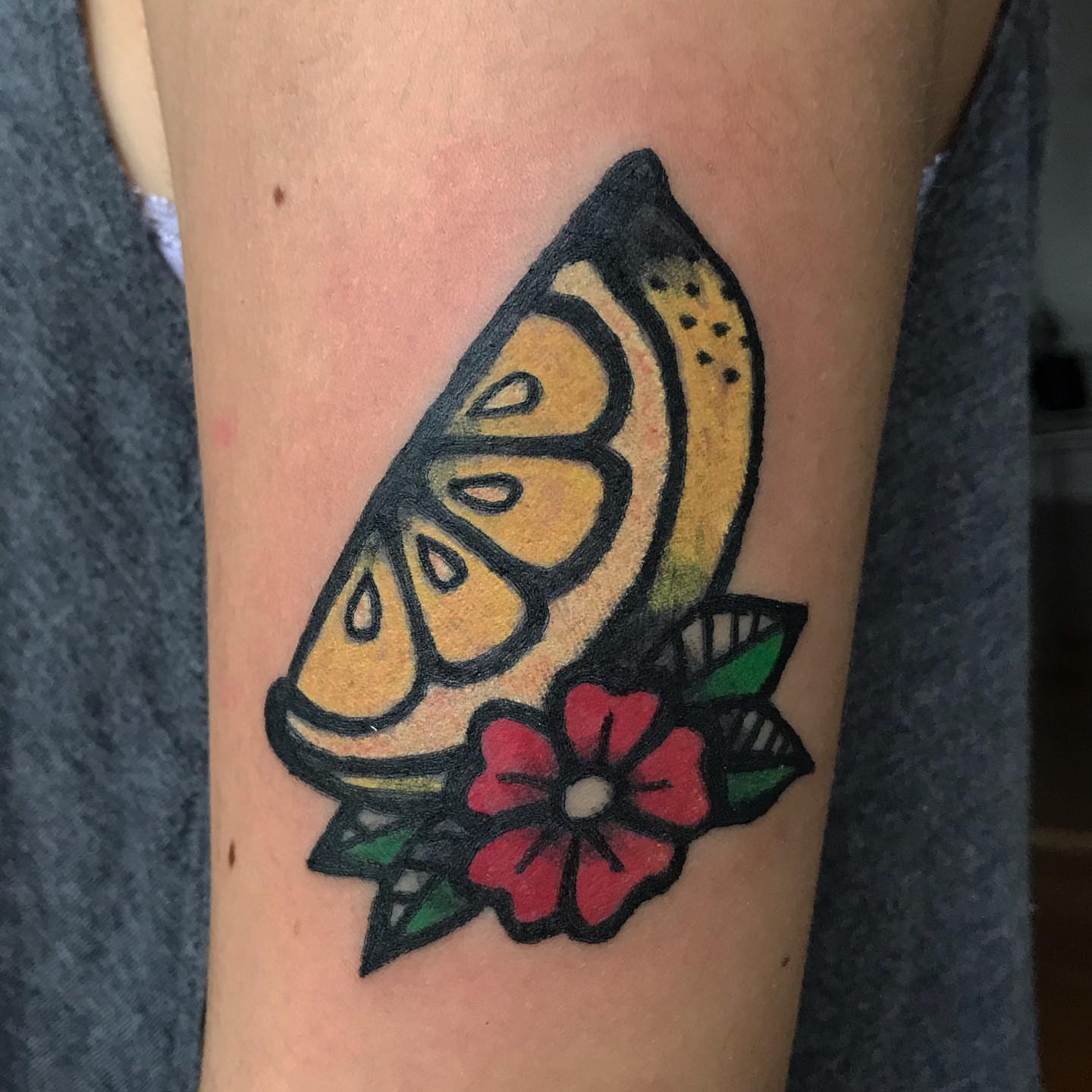 Lemon slice and flower American traditional tattoo on the forearm by Júlia Sorrino