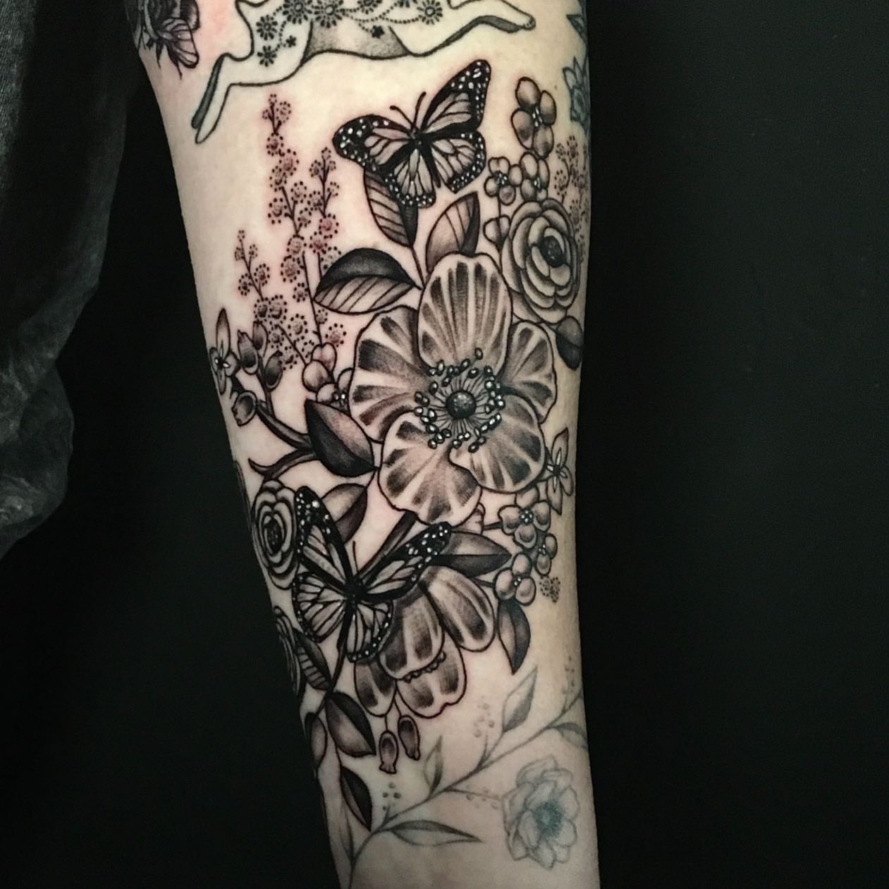 Butterflies and flowers realism tattoo on the forearm by Ray Marie