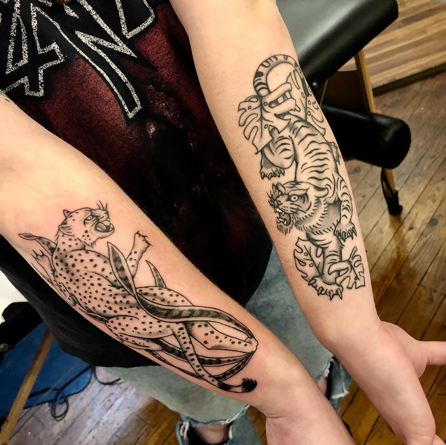 Cheetah and tiger American traditional tattoo on the forearm by Dave Shurman