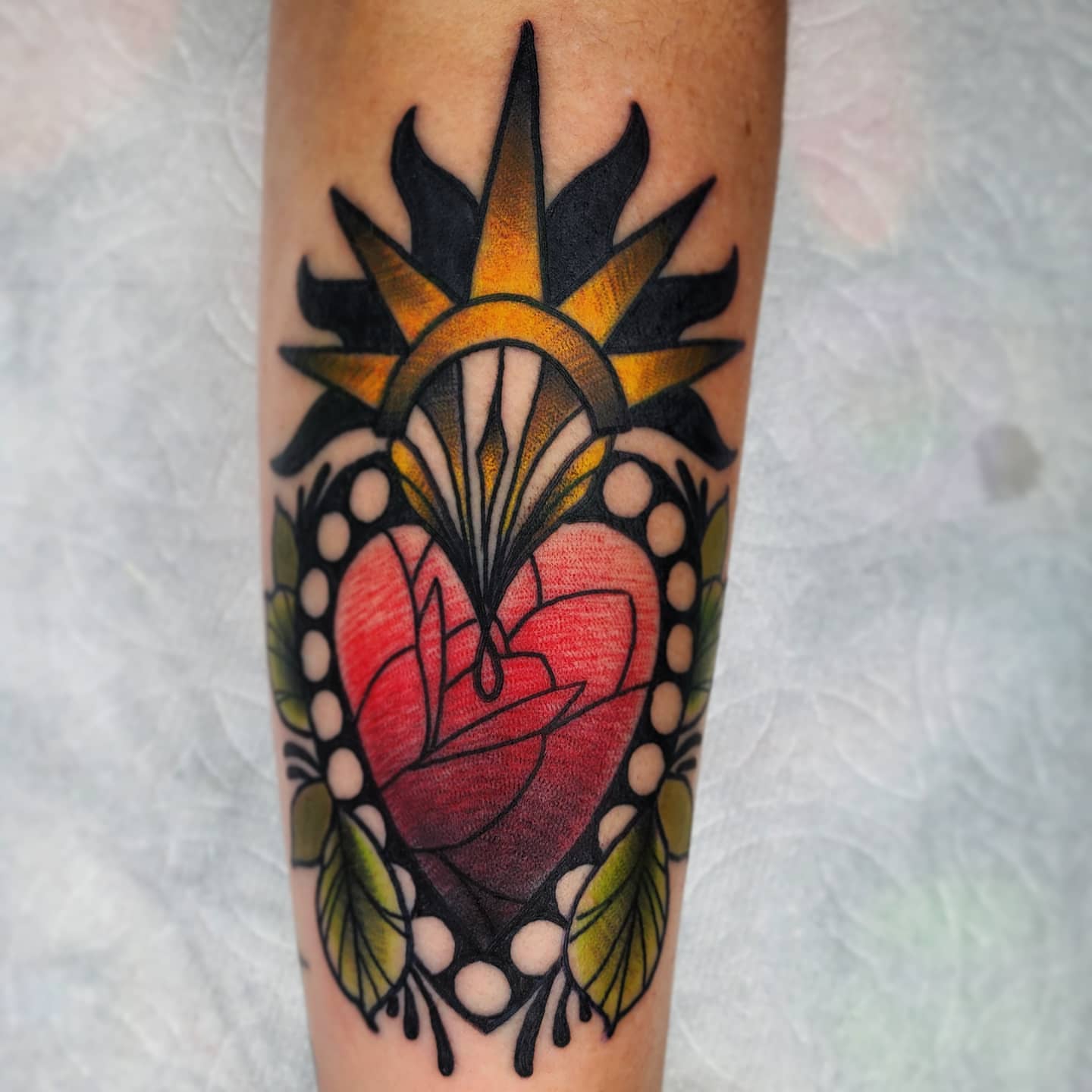 Heart with sunburst American traditional tattoo on the forearm by TattoosbyPhatboi