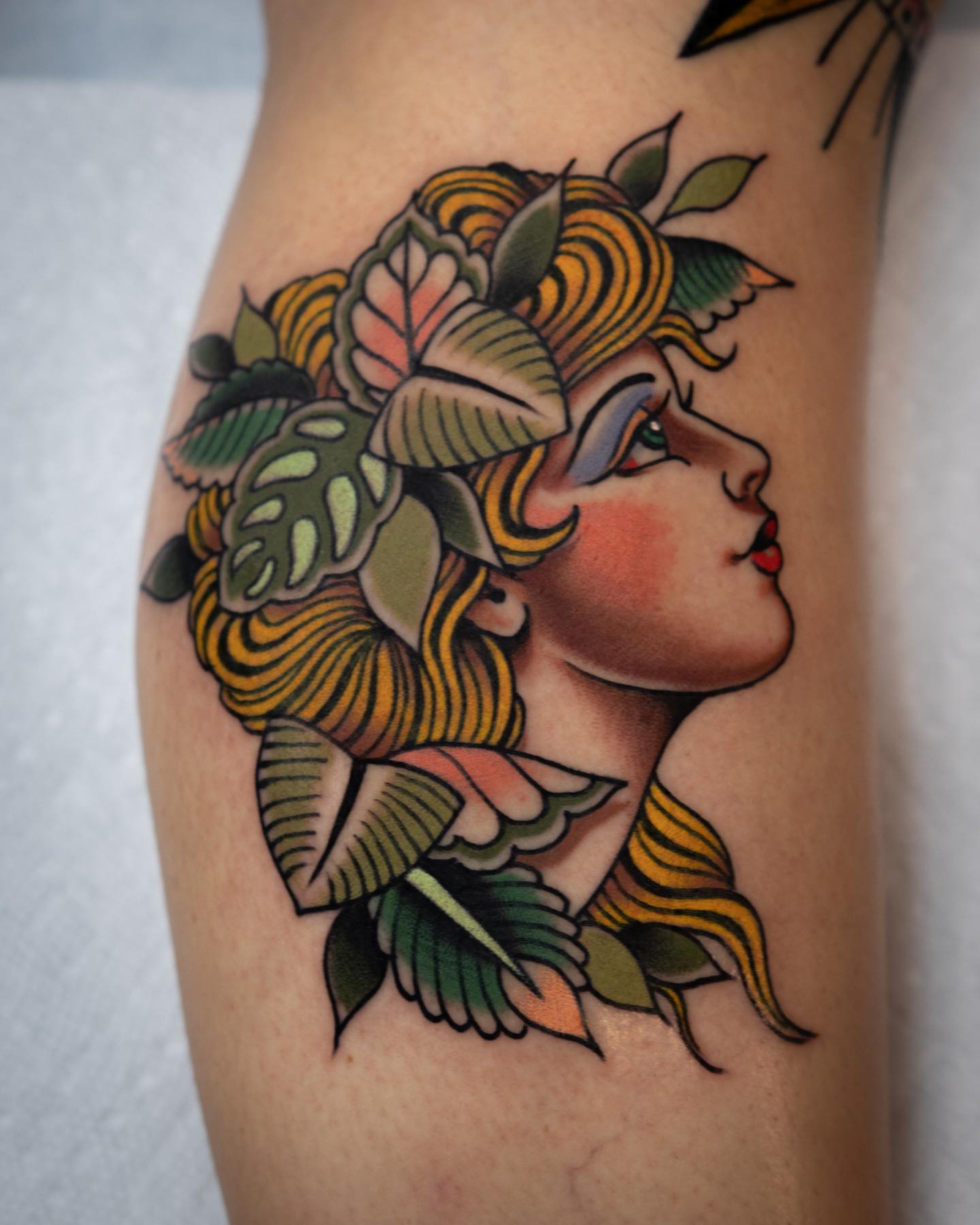 Floral woman profile American traditional tattoo on the thigh by Danny Derrick, San Luis Obispo, California