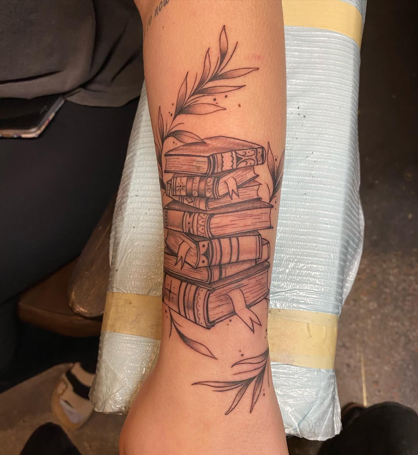 Stack of books black and grey tattoo on the forearm by Valen Laska